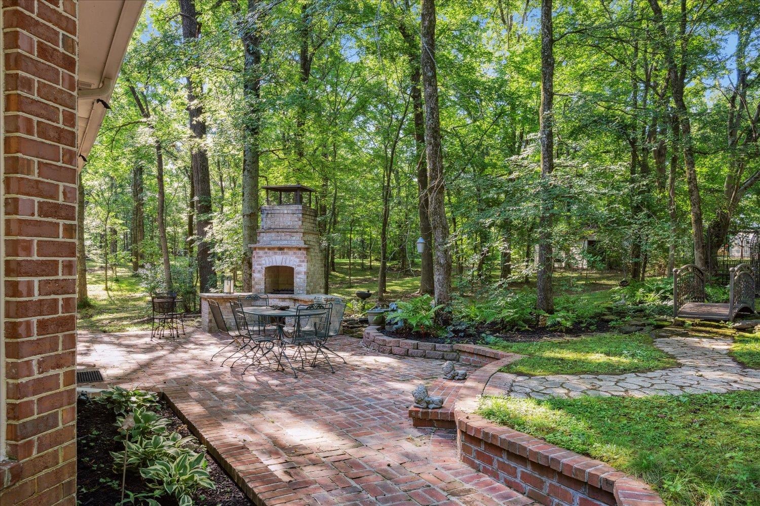 BRICK PATIO with Outdoor Grill/Fireplace, Stone Pathways, and Gardens Galore! Perfect for enjoying the birds and views of the incredible rear grounds!