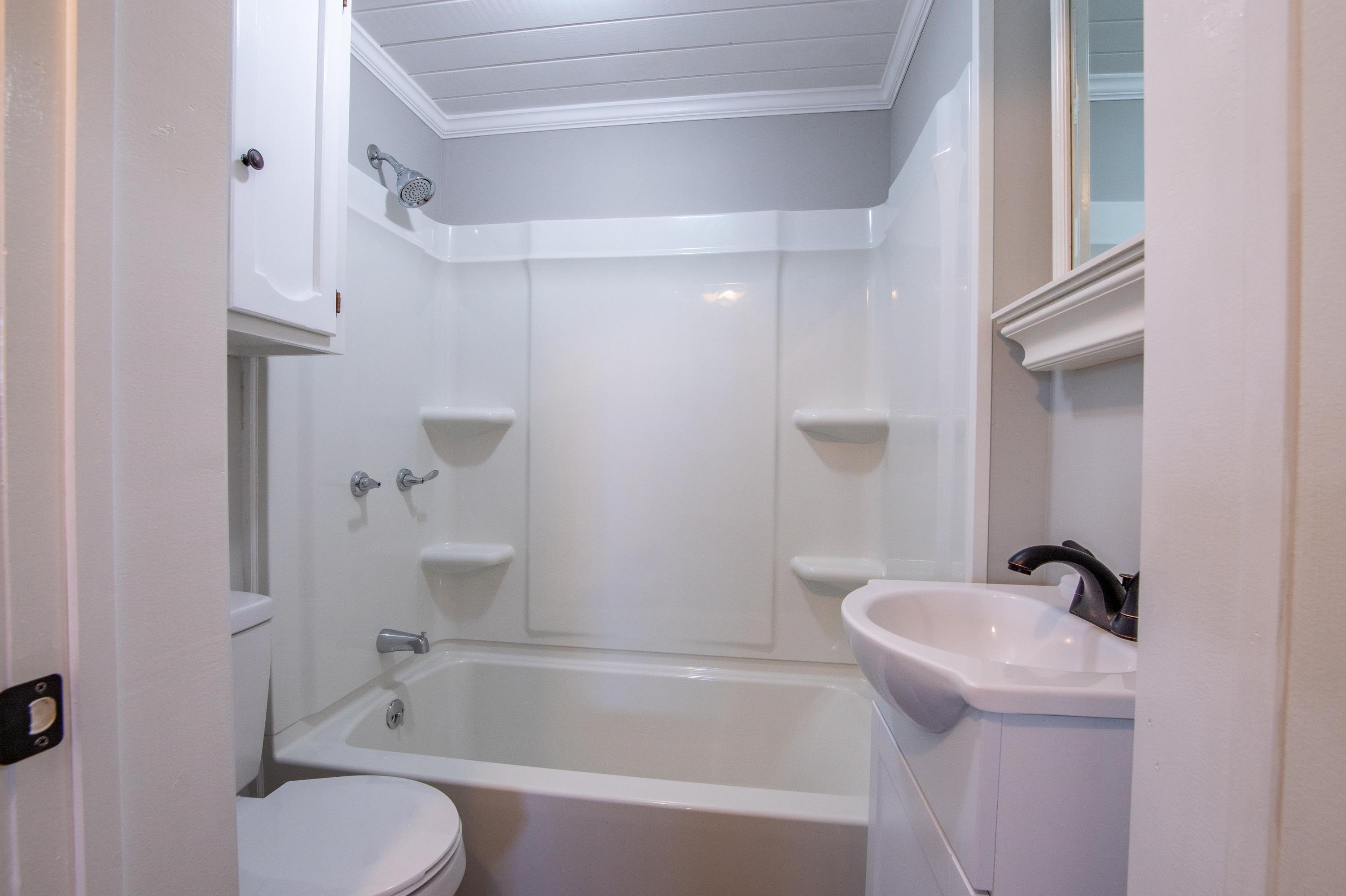 Full bathroom featuring crown molding, shower / bathing tub combination, and toilet