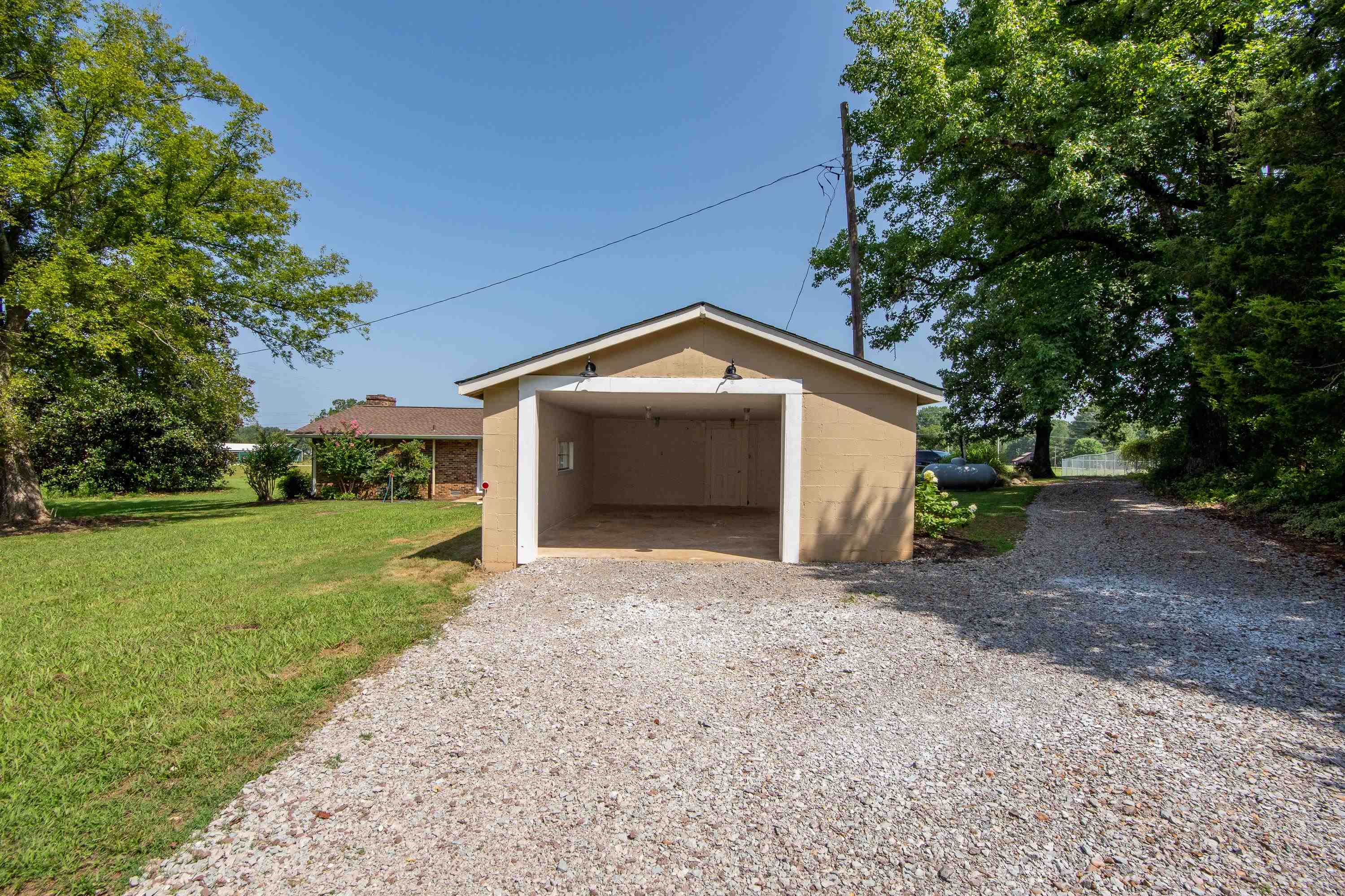 Garage with a carport and a yard