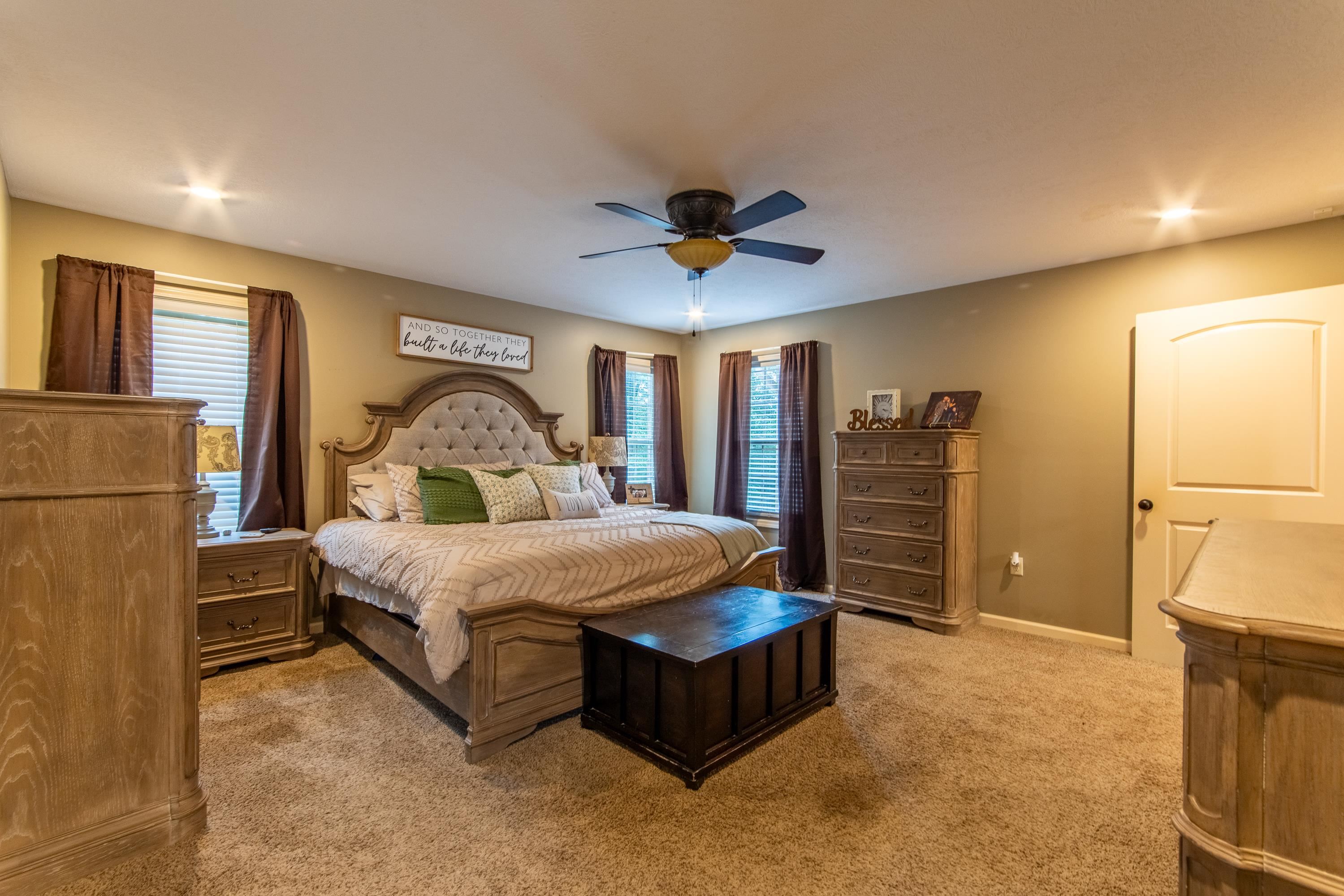 Carpeted bedroom featuring ceiling fan