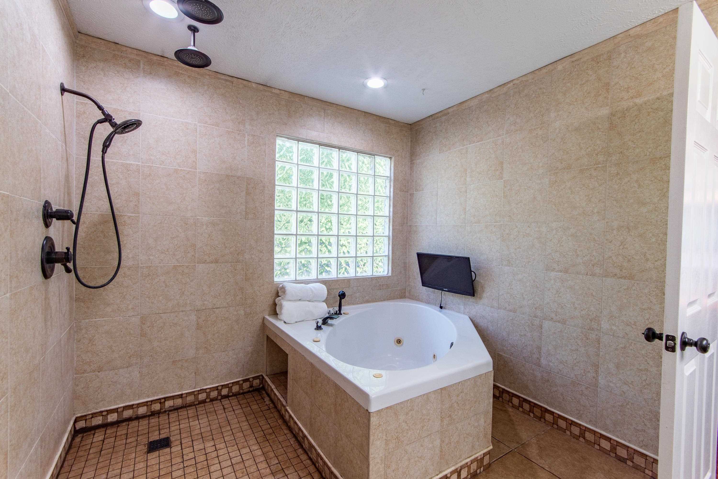 Bathroom with tile patterned flooring, tile walls, independent shower and bath, and a textured ceiling