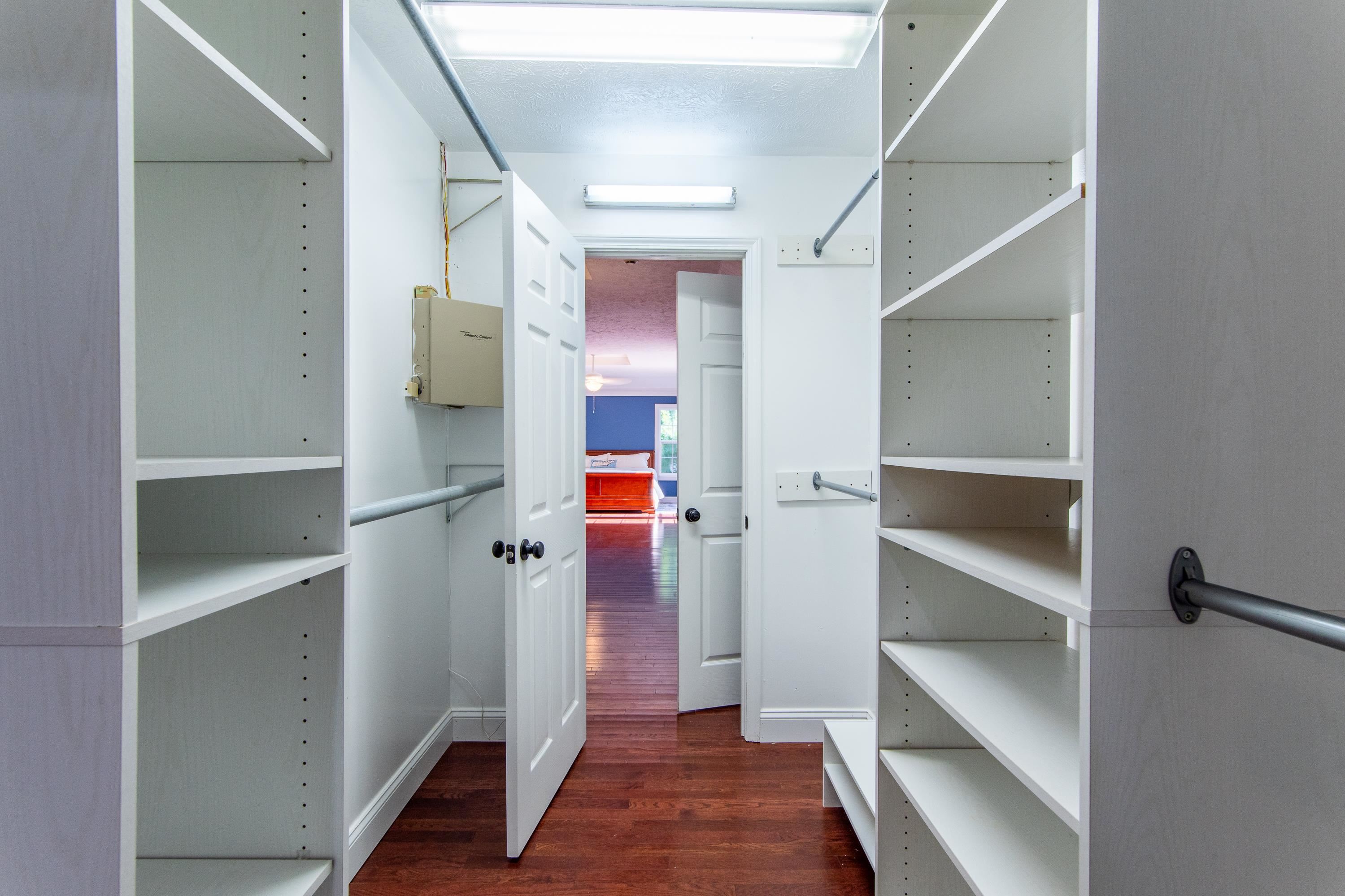 Walk in closet with dark hardwood / wood-style floors