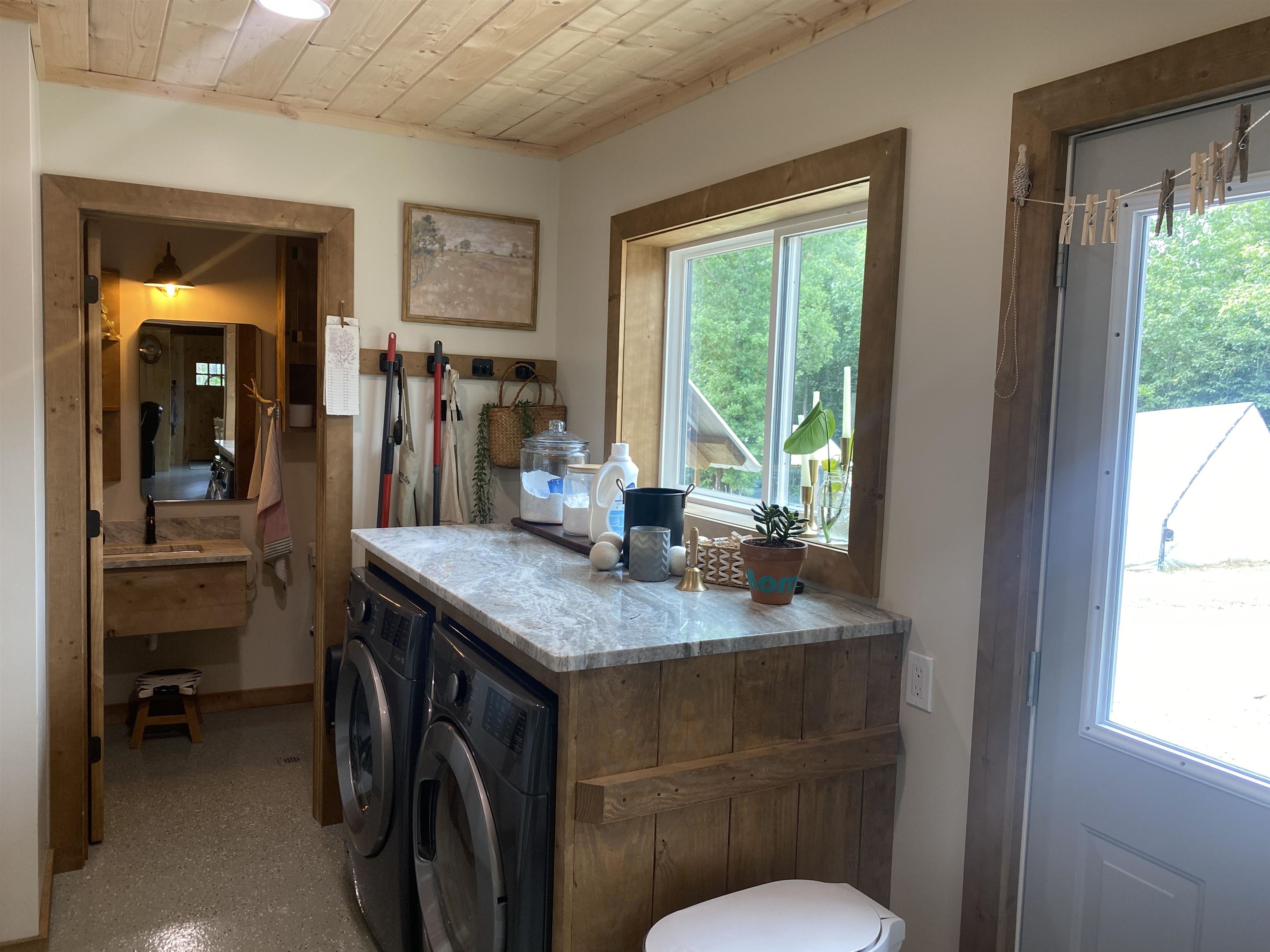 Washroom featuring washer and clothes dryer and a healthy amount of sunlight