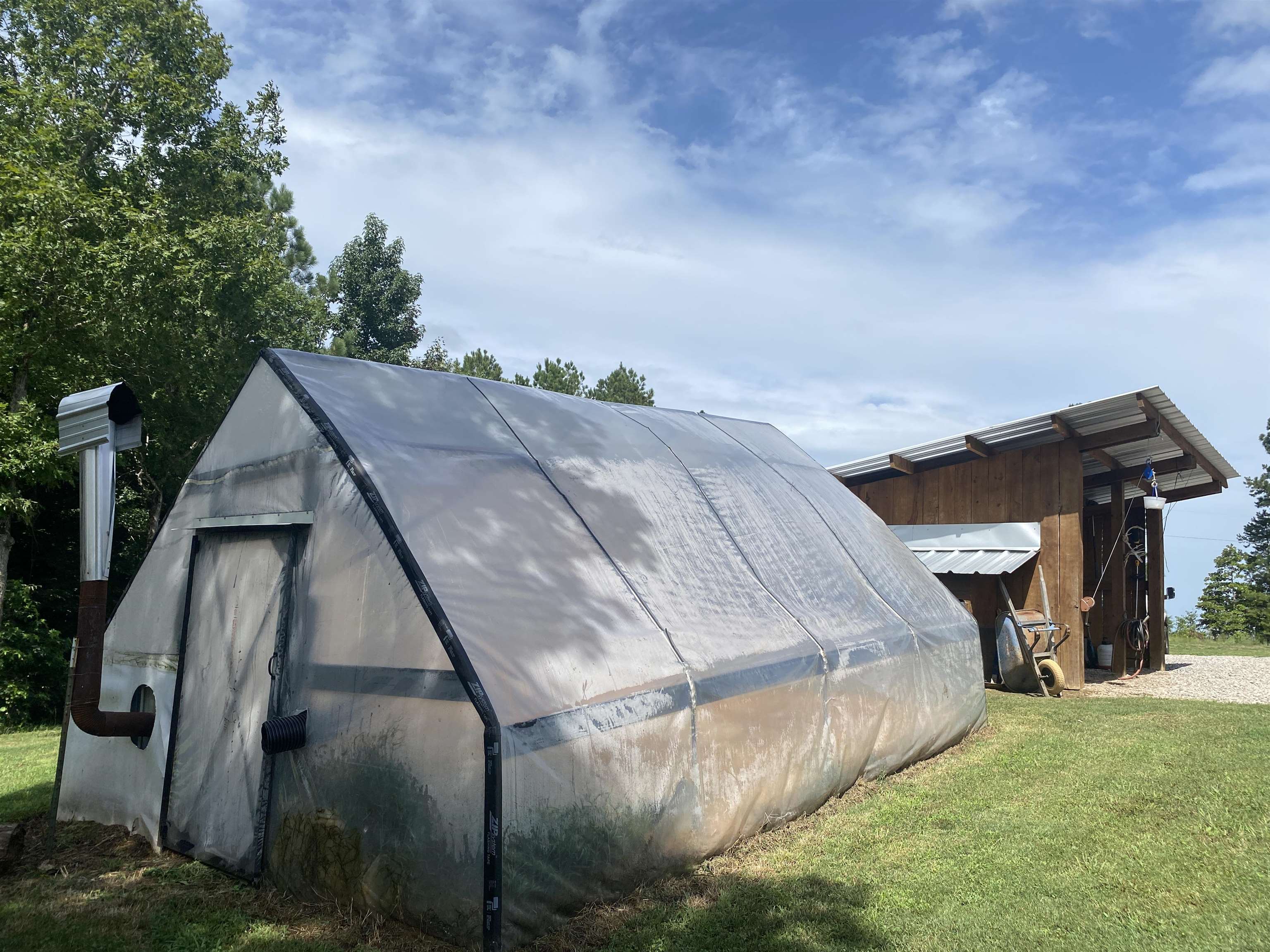 View of property exterior featuring a yard and an outbuilding