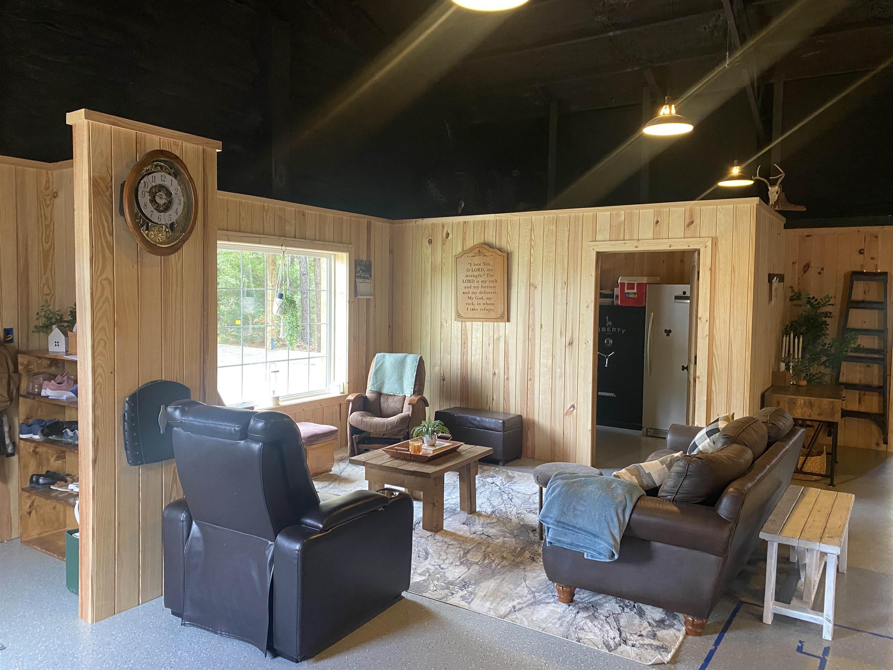 Living room featuring wooden walls and a high ceiling