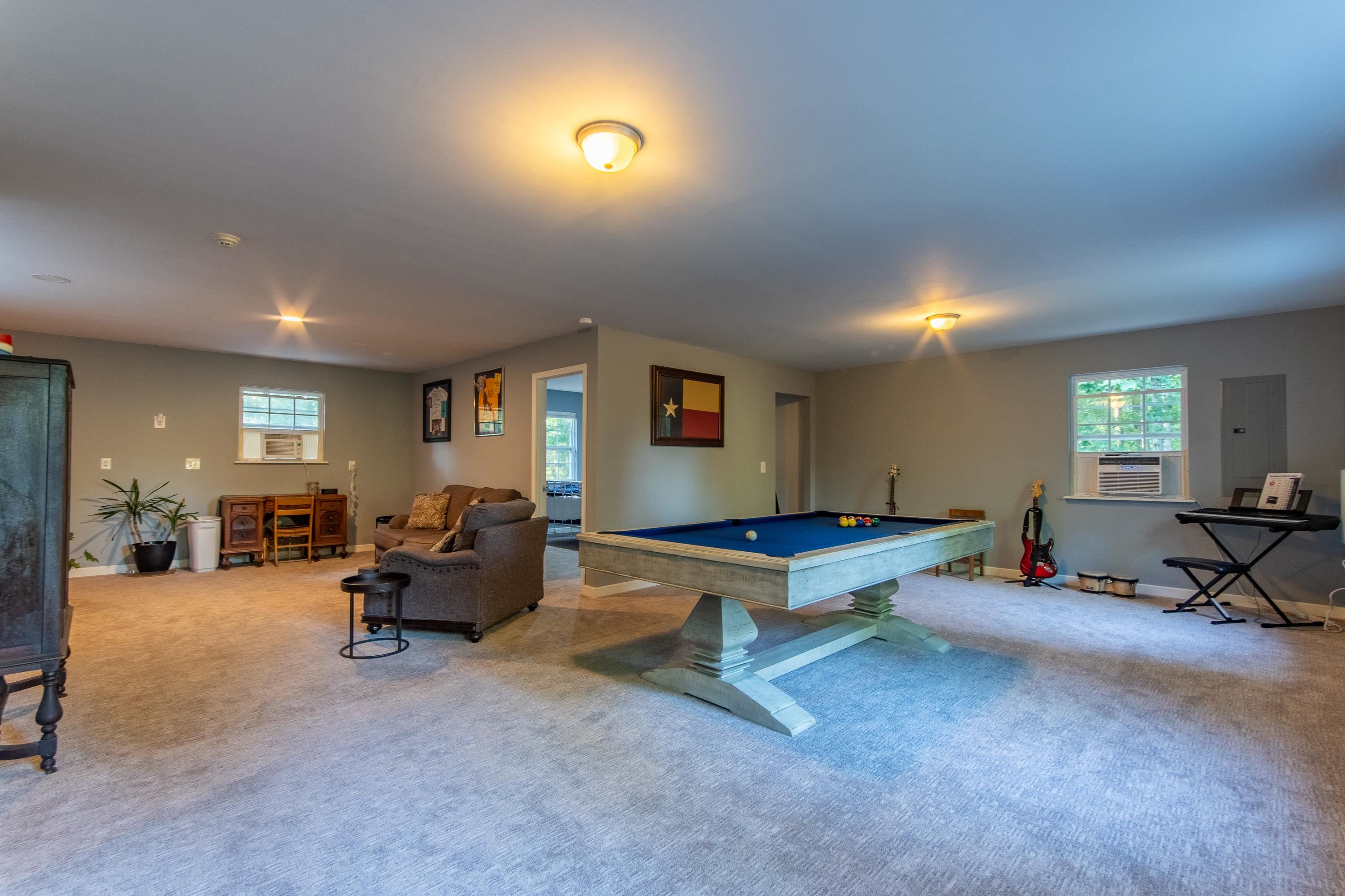 Rec room featuring light colored carpet, electric panel, and billiards