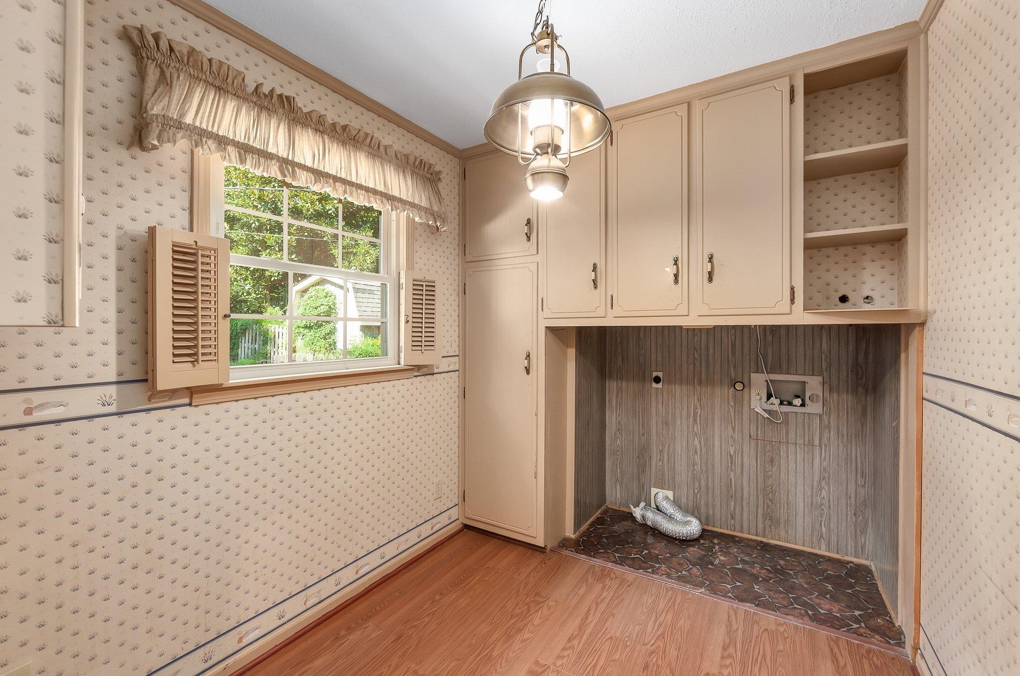 Laundry area with washer hookup, wood-type flooring, crown molding, and cabinets