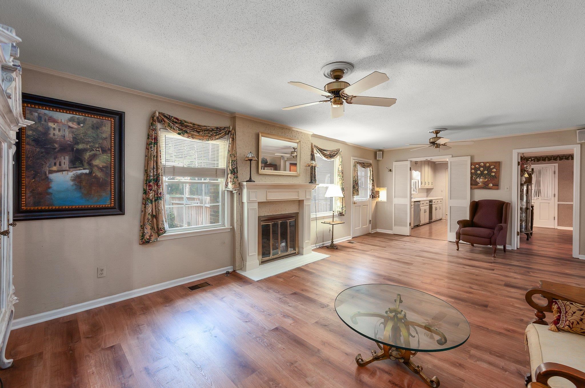 Unfurnished living room with hardwood / wood-style flooring, a textured ceiling, and ceiling fan