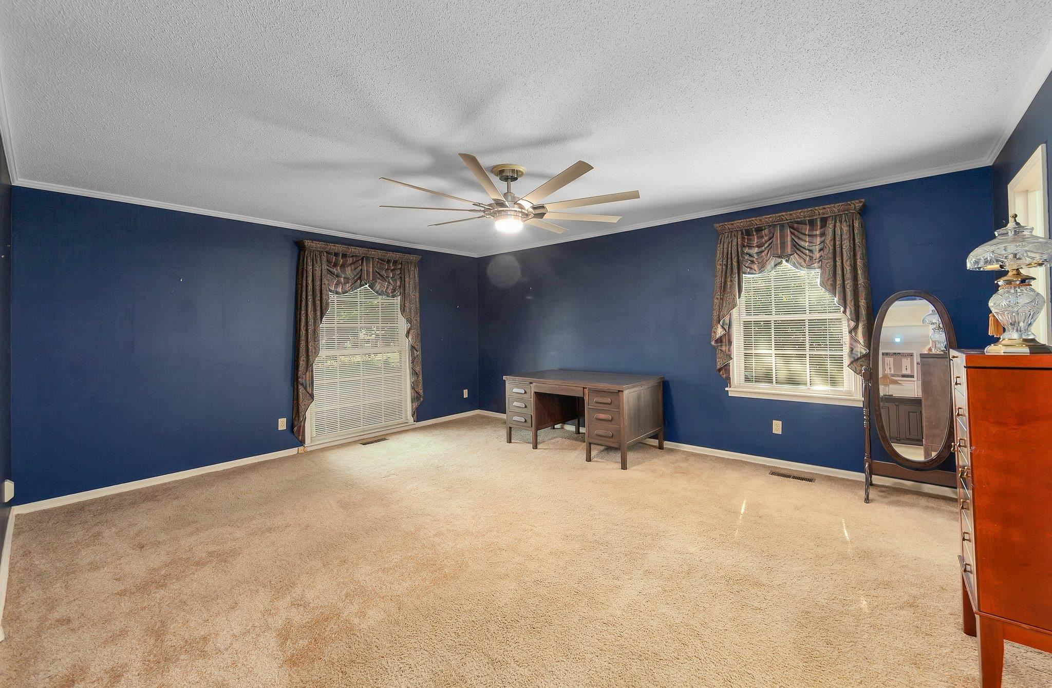 Interior space featuring a textured ceiling, ceiling fan, and ornamental molding