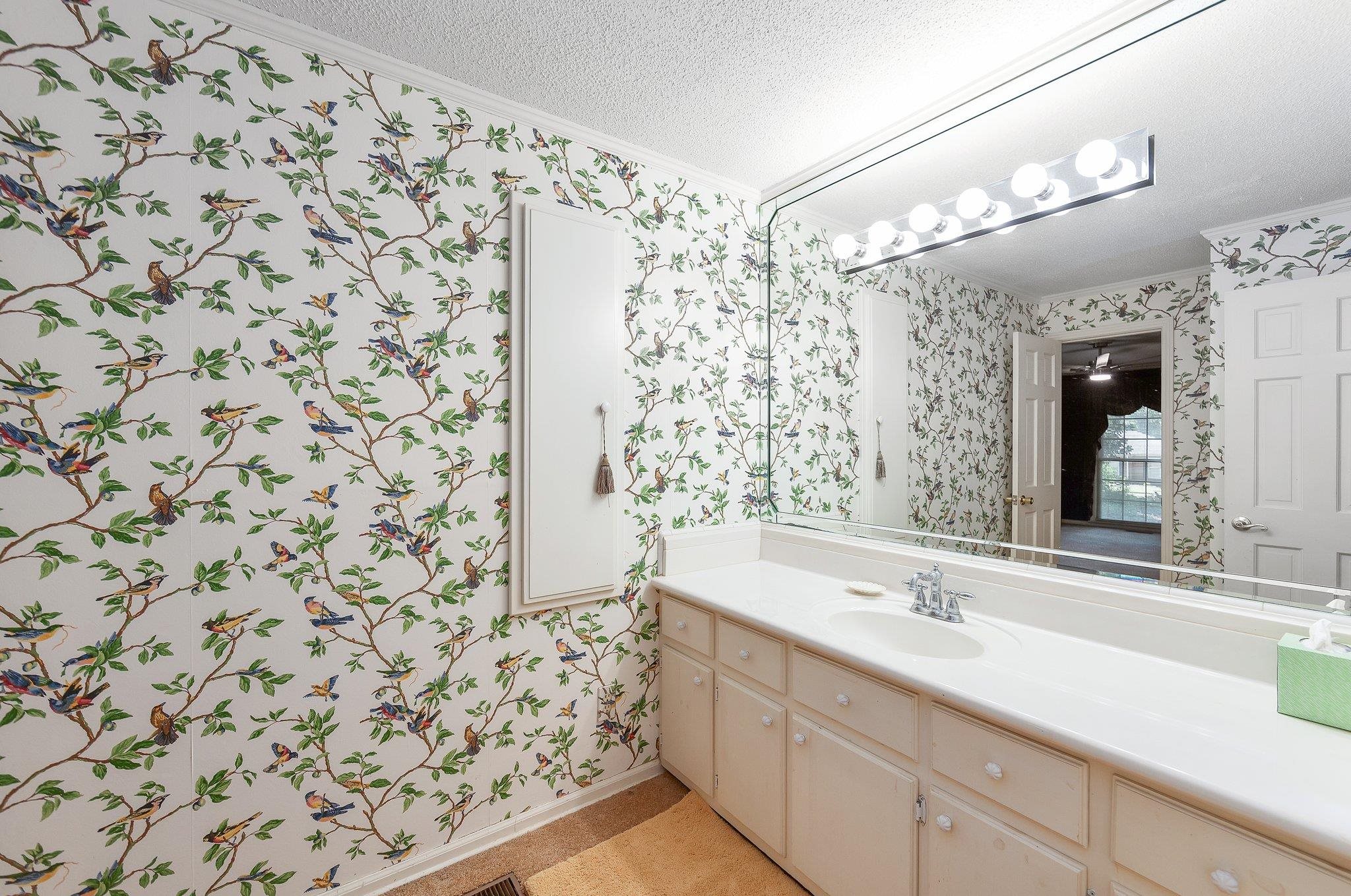 Bathroom with vanity, a textured ceiling, and crown molding