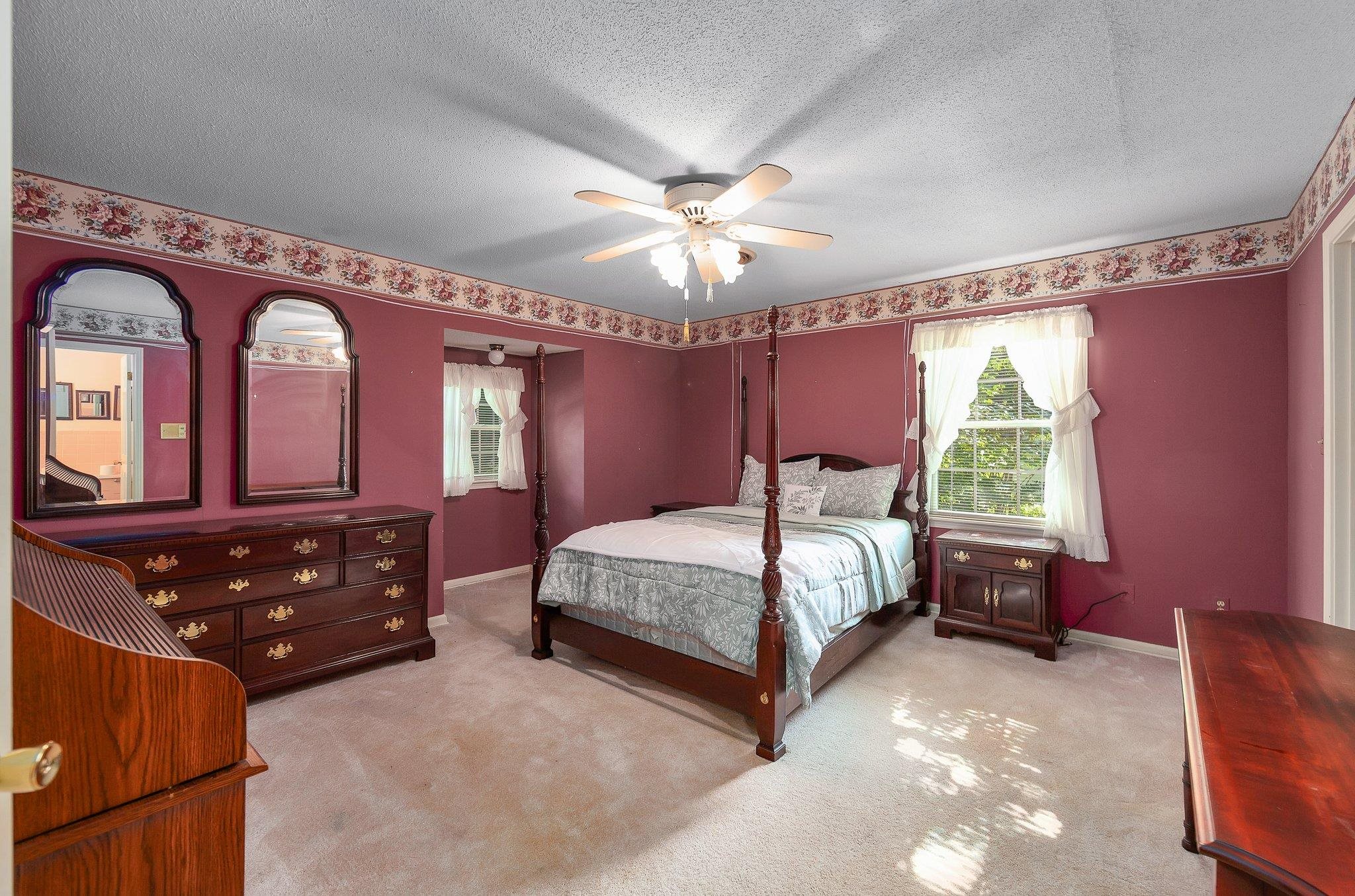 Carpeted bedroom featuring a textured ceiling and ceiling fan