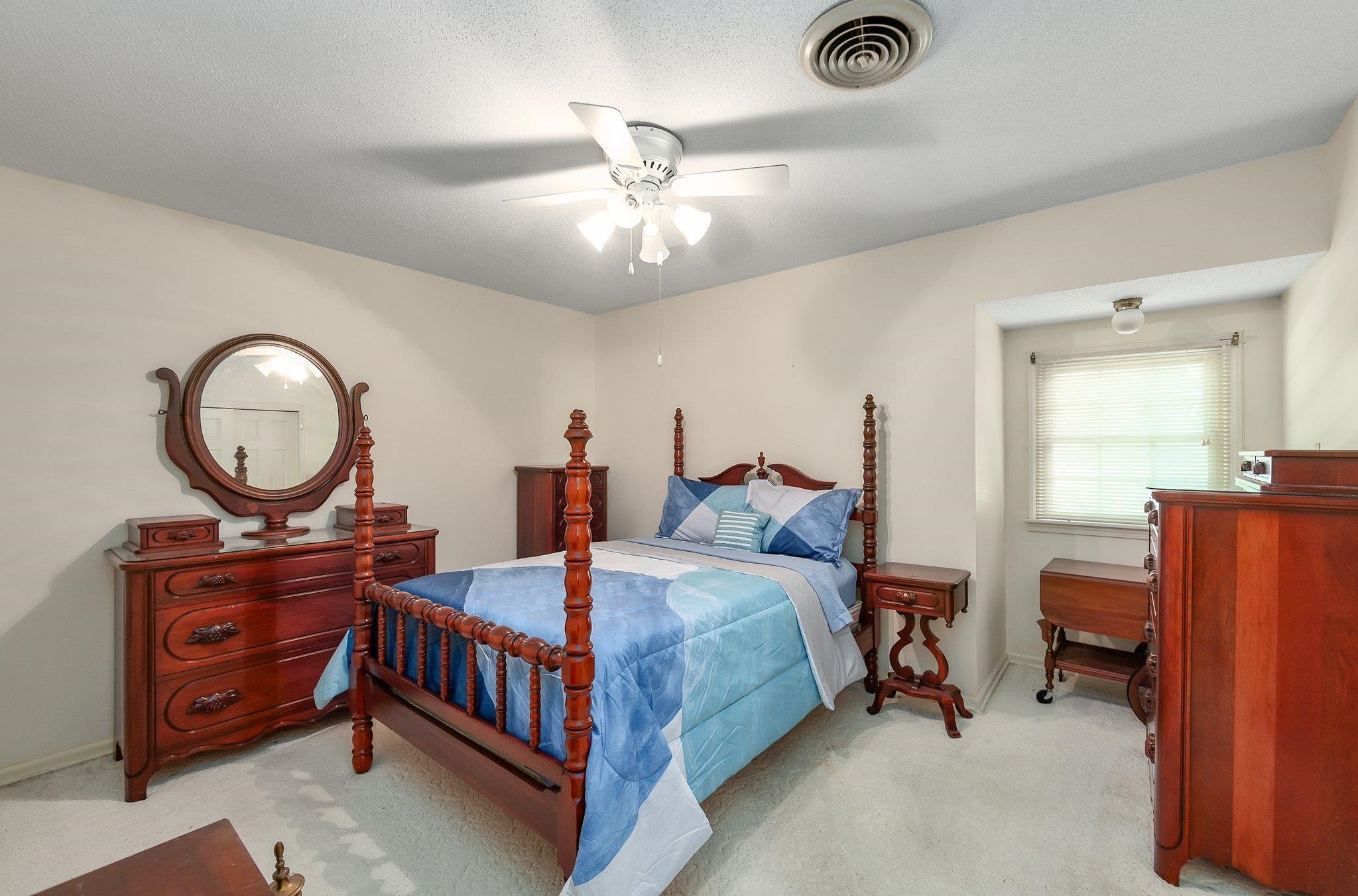 Bedroom with light colored carpet and ceiling fan