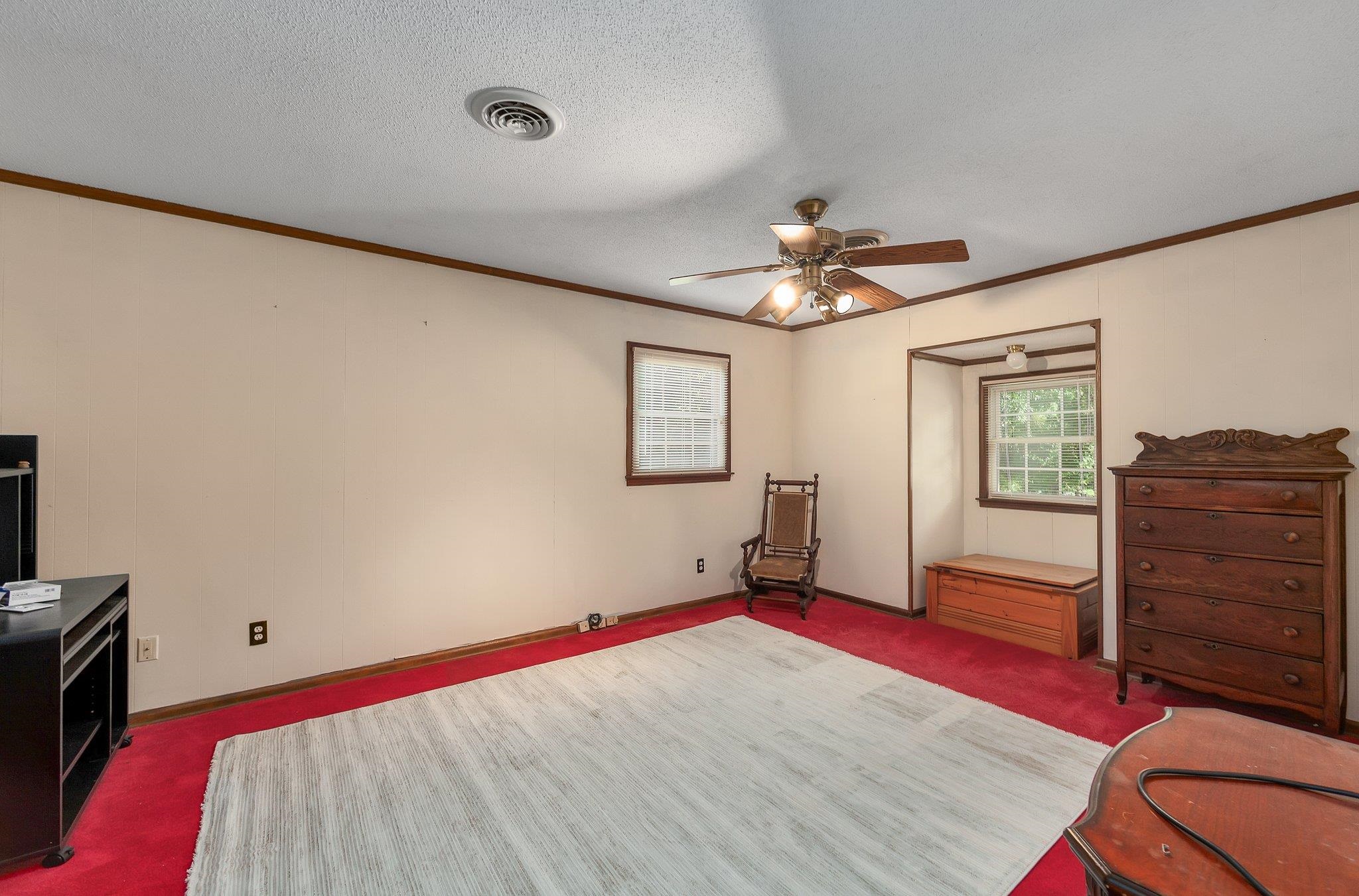 Carpeted bedroom featuring a textured ceiling and ceiling fan