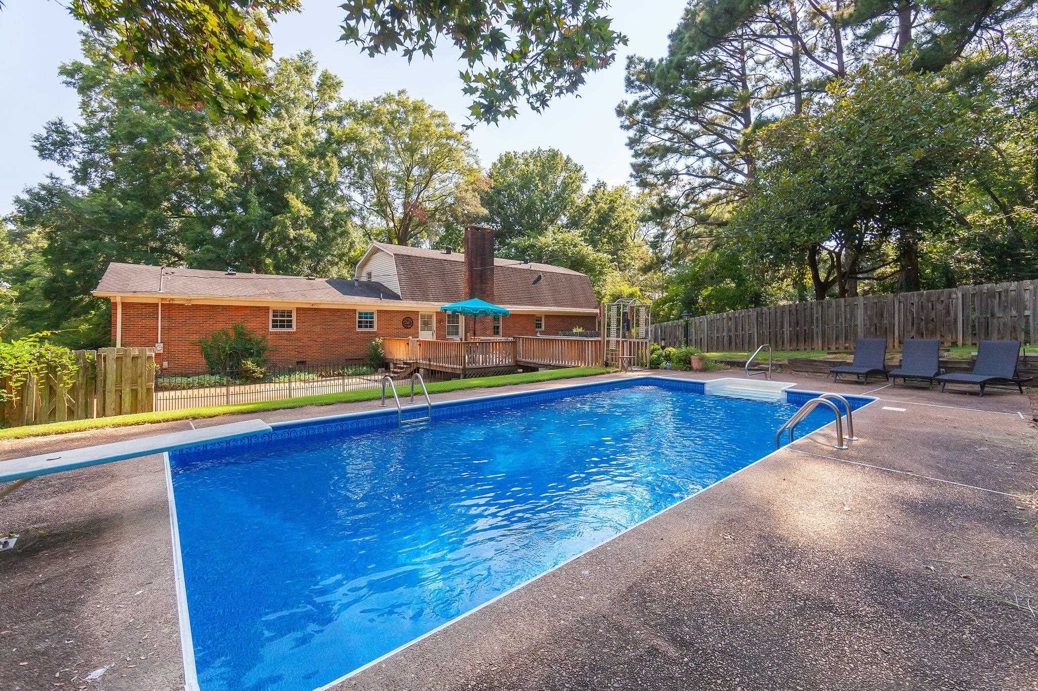 View of swimming pool featuring a deck and a diving board