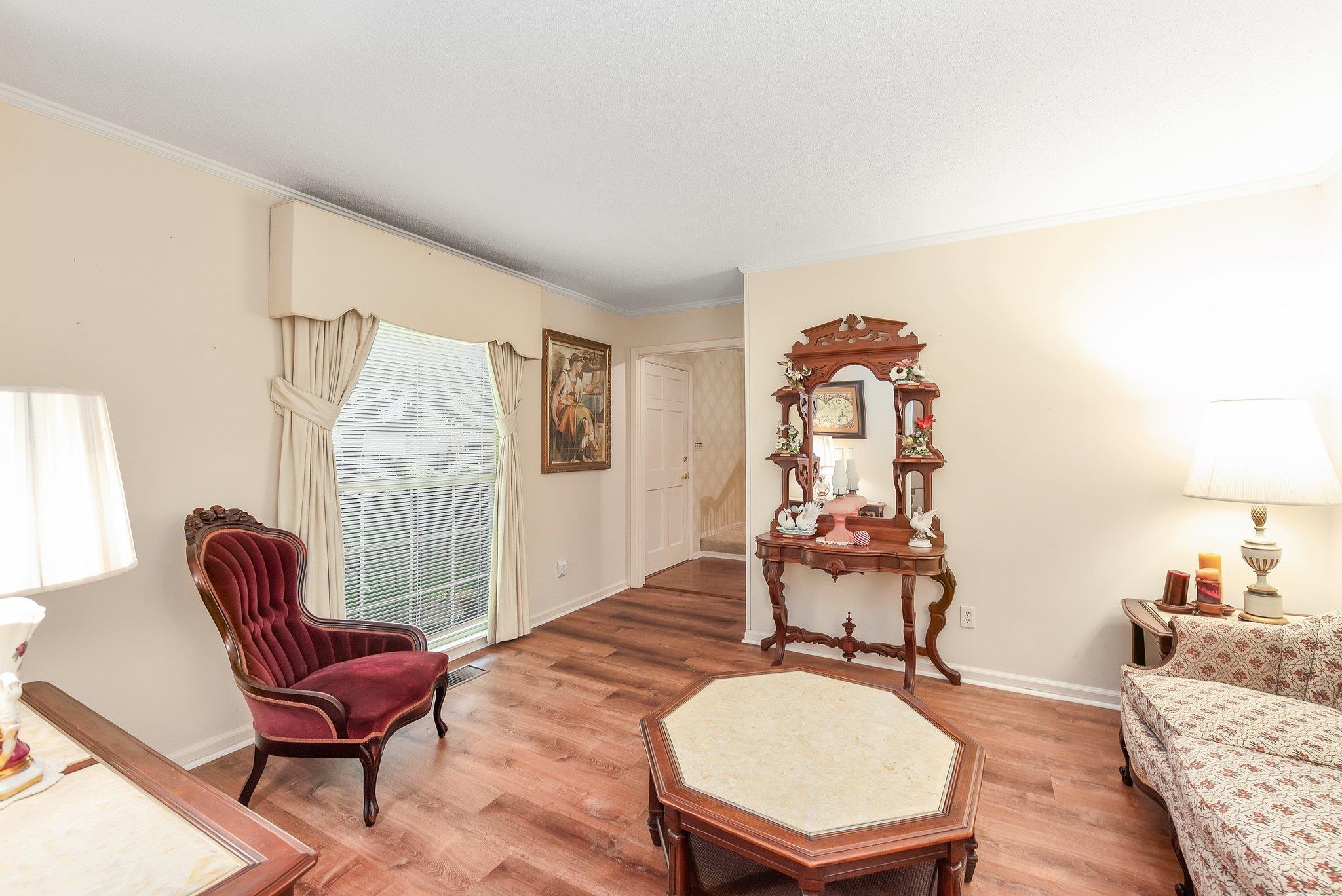 Living area with hardwood / wood-style flooring and ornamental molding