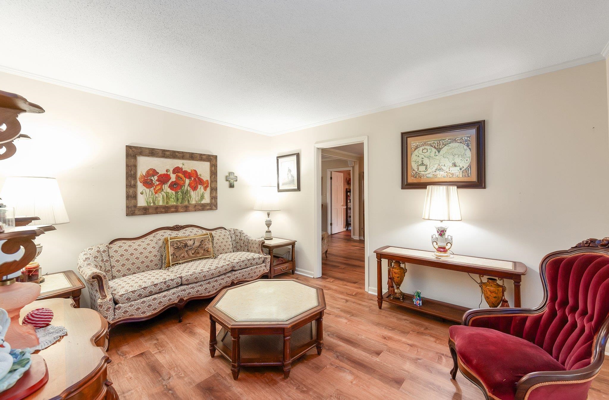 Living room with crown molding and hardwood / wood-style floors