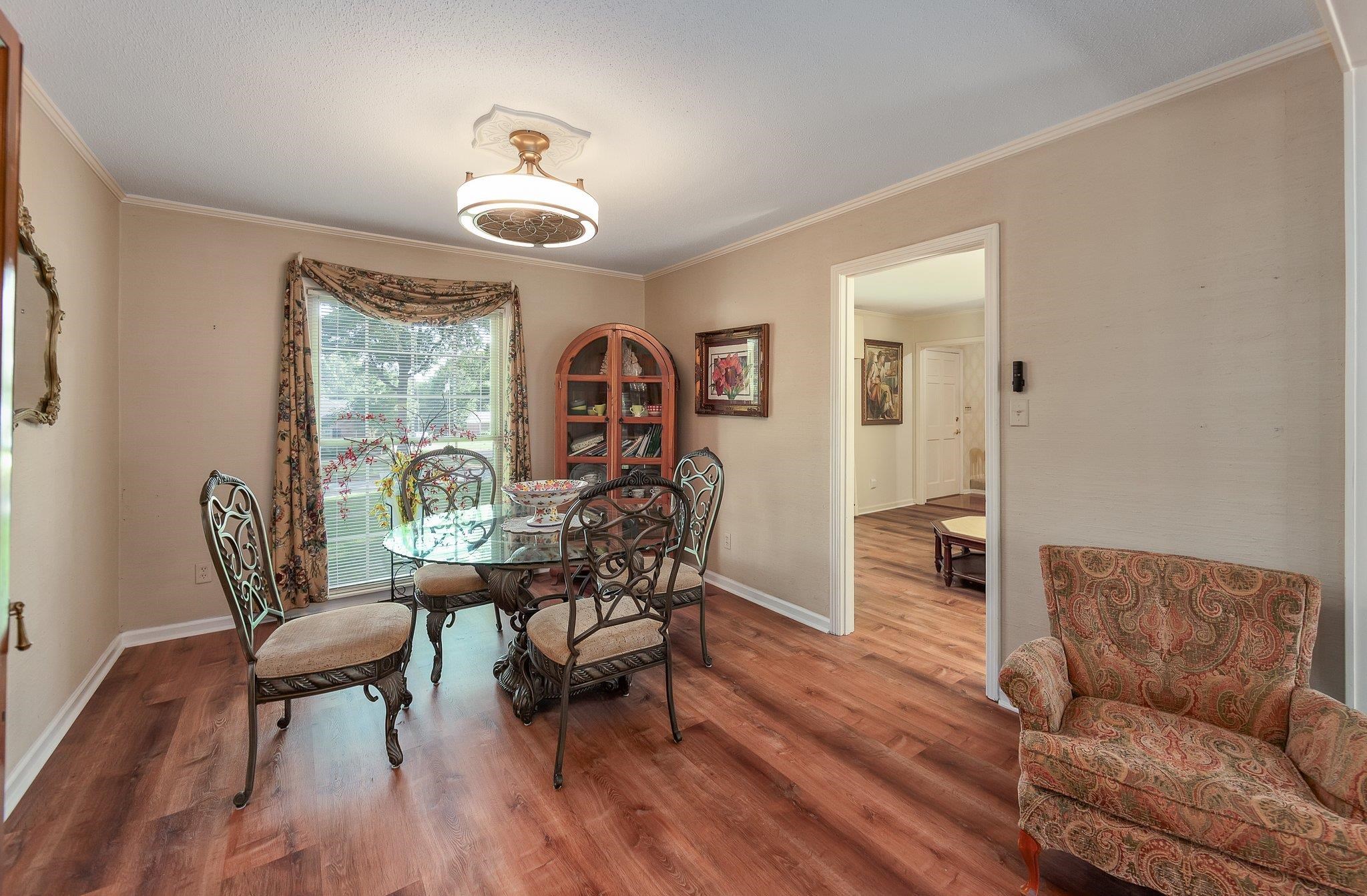 Dining space featuring wood-type flooring and ornamental molding