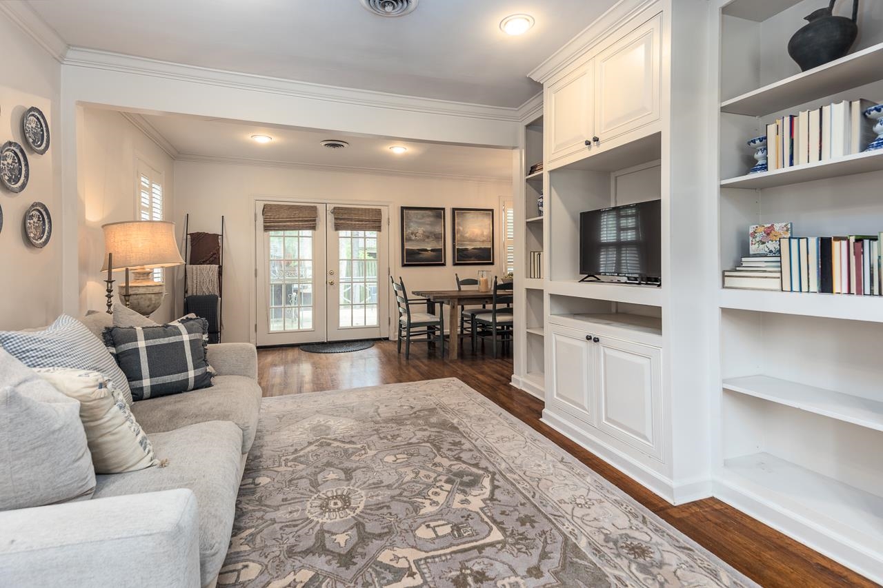 Living room featuring built in features, dark hardwood / wood-style floors, french doors, and ornamental molding