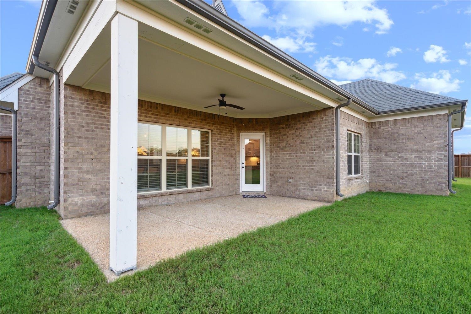 Back of property with a yard, a patio, and ceiling fan