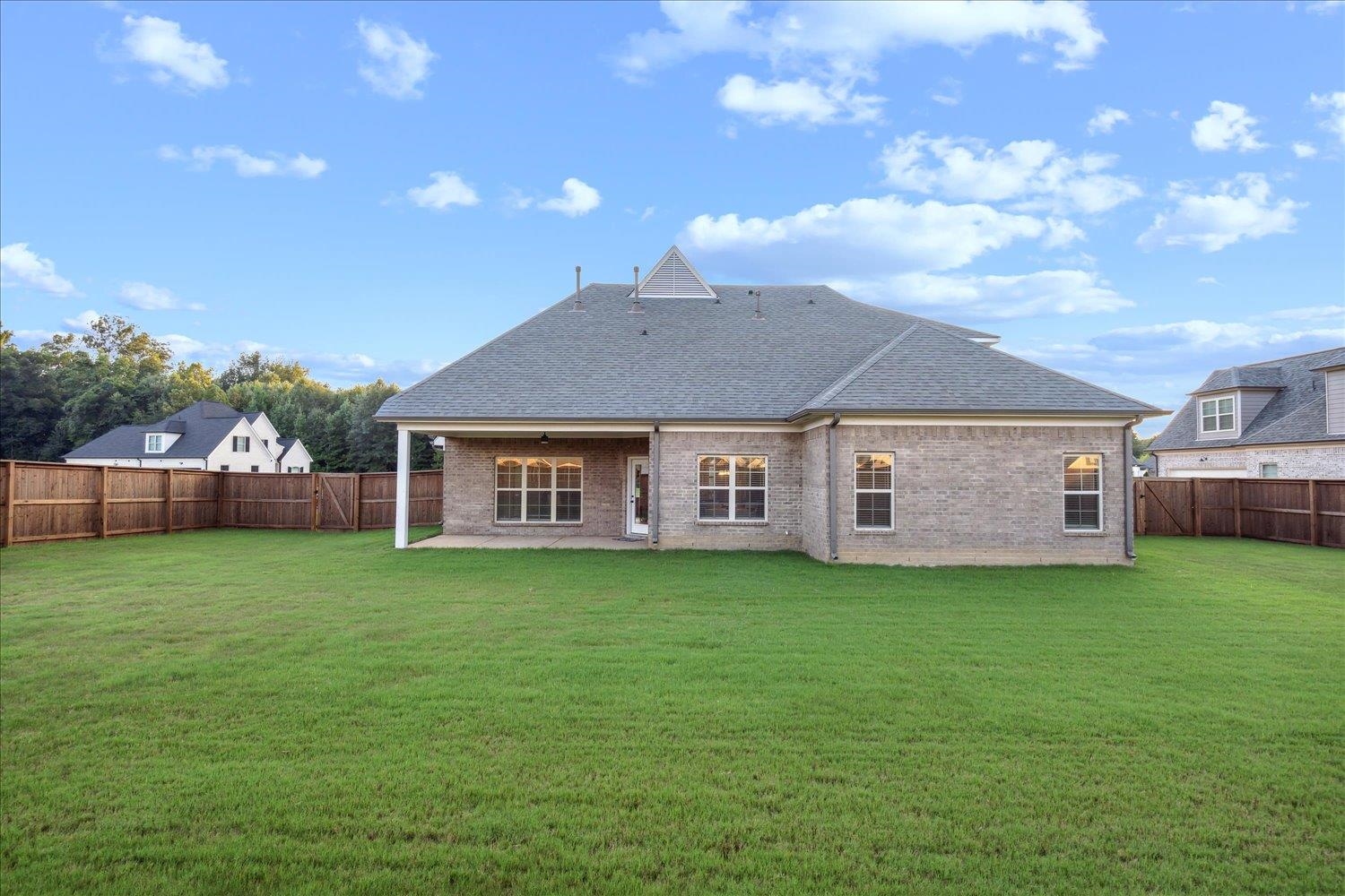 Back of house with a patio area and a lawn