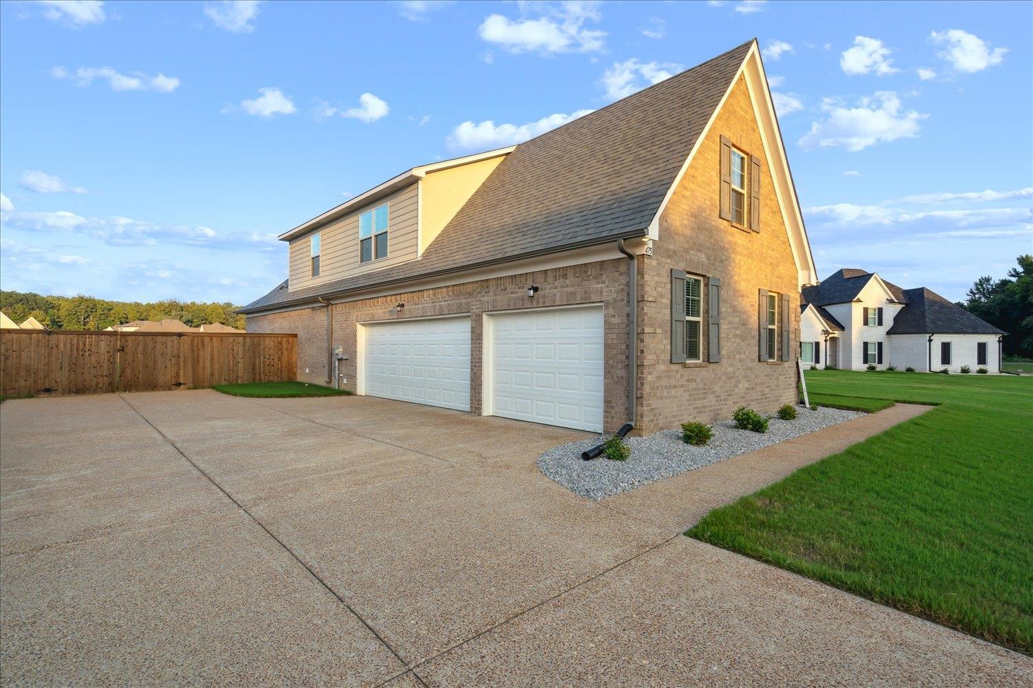 View of property exterior featuring a garage and a yard