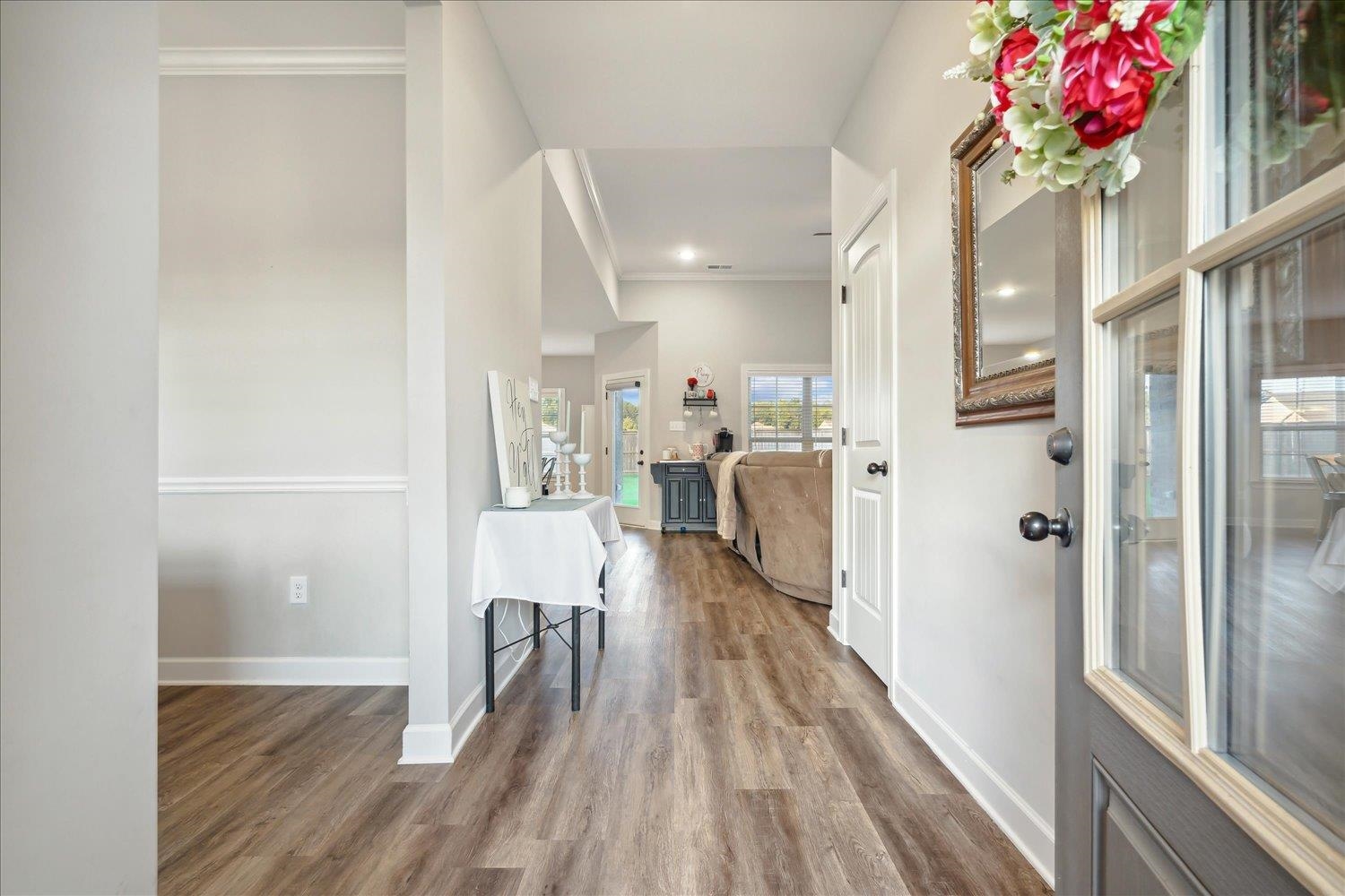 Corridor featuring crown molding and wood-type flooring