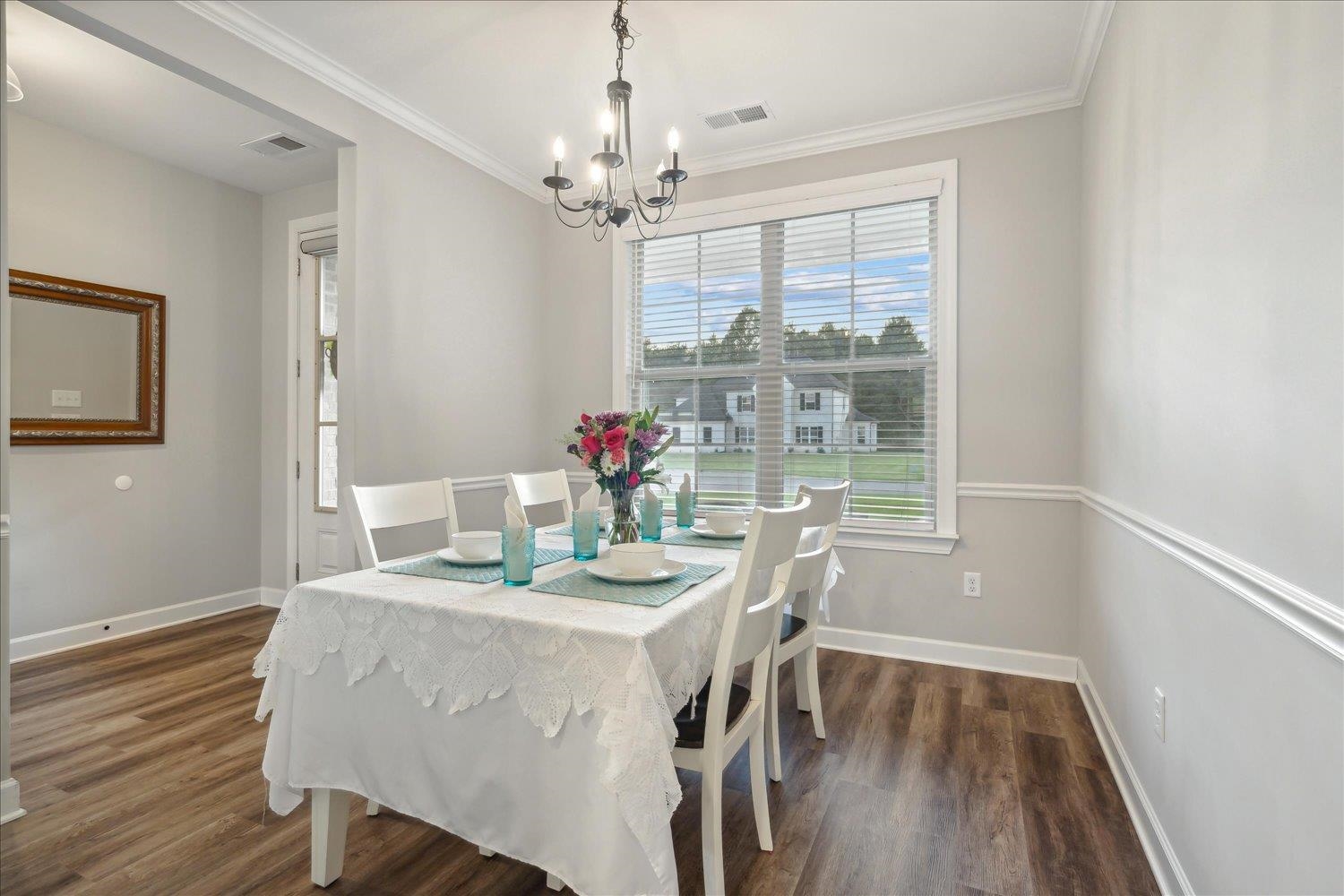 Dining room featuring ornamental molding, dark hardwood / wood-style floors, and a notable chandelier