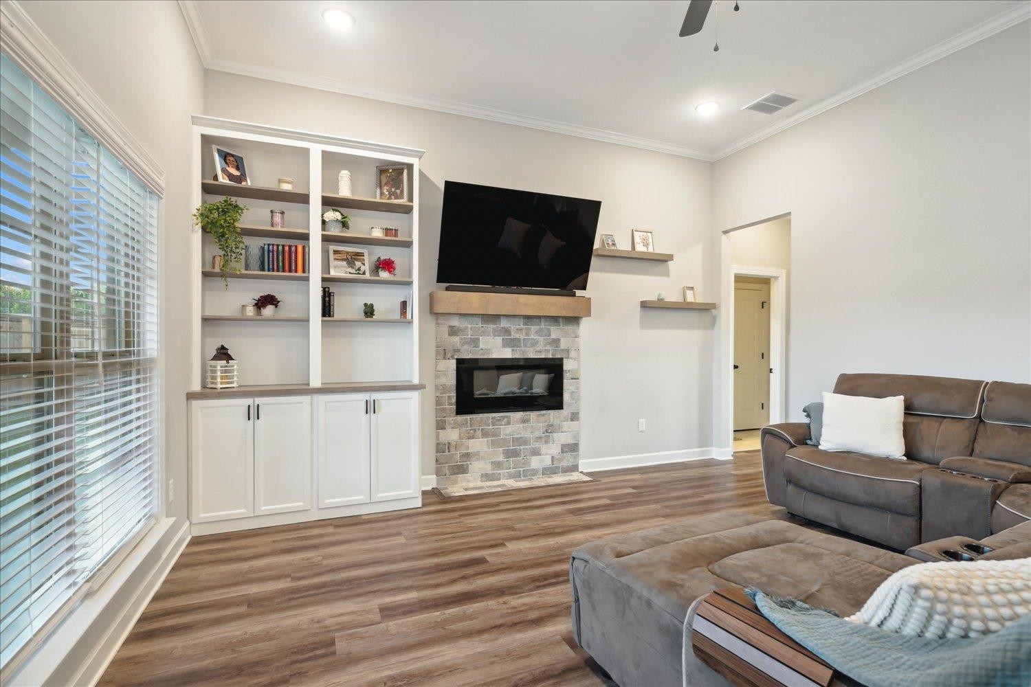 Living room featuring plenty of natural light, crown molding, ceiling fan, and hardwood / wood-style floors