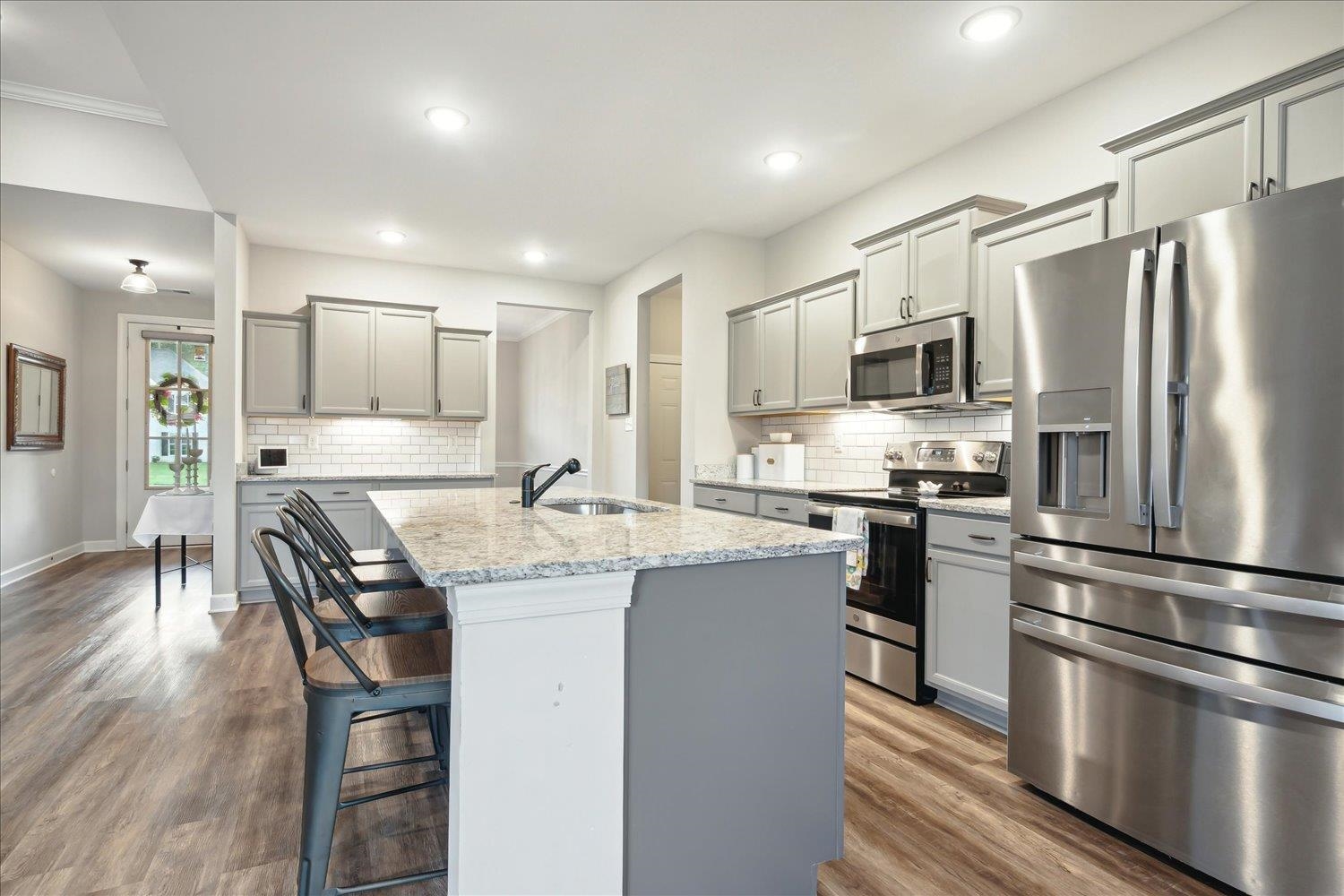 Kitchen with sink, wood-type flooring, decorative backsplash, and stainless steel appliances