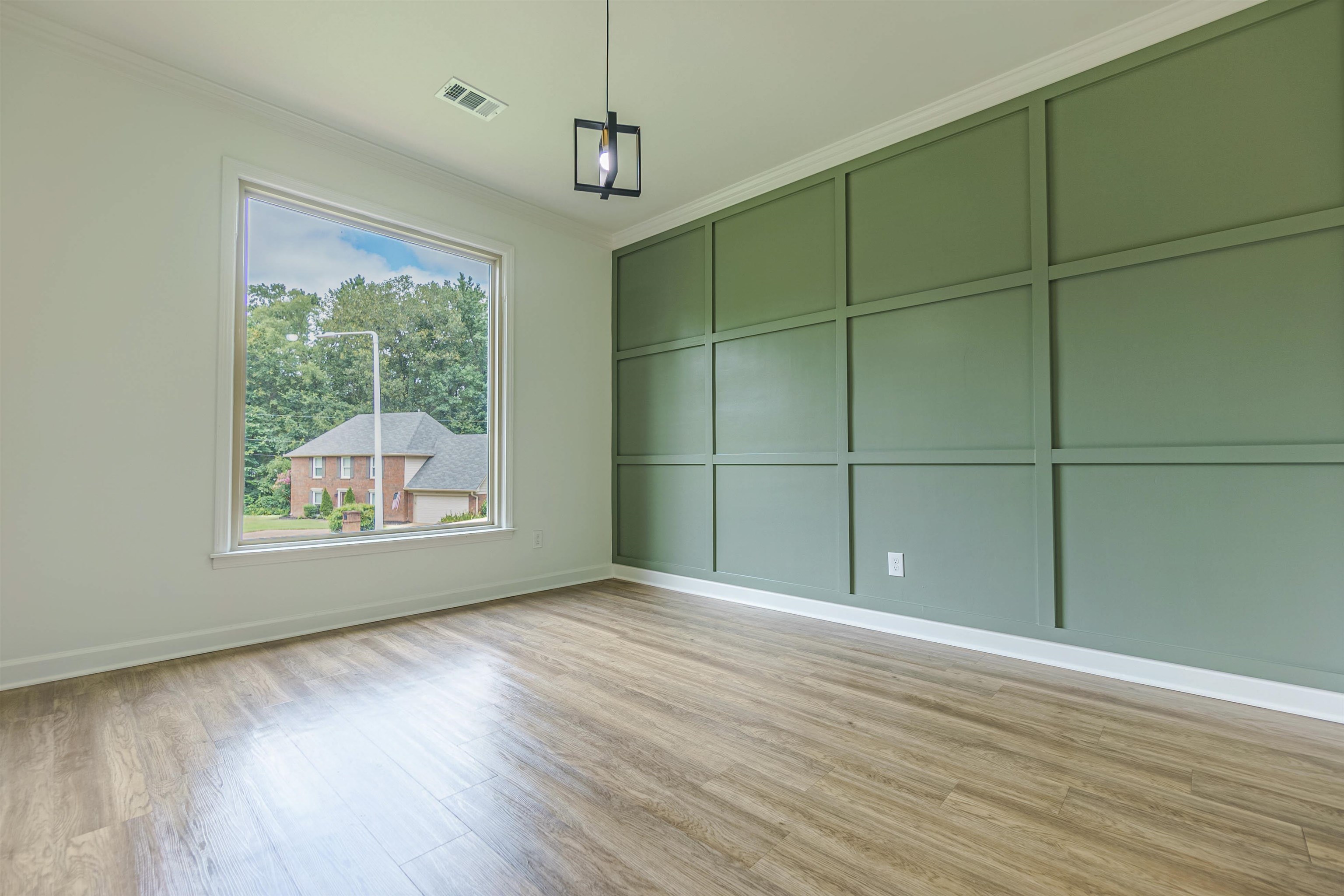 Empty room with light hardwood / wood-style flooring and crown molding