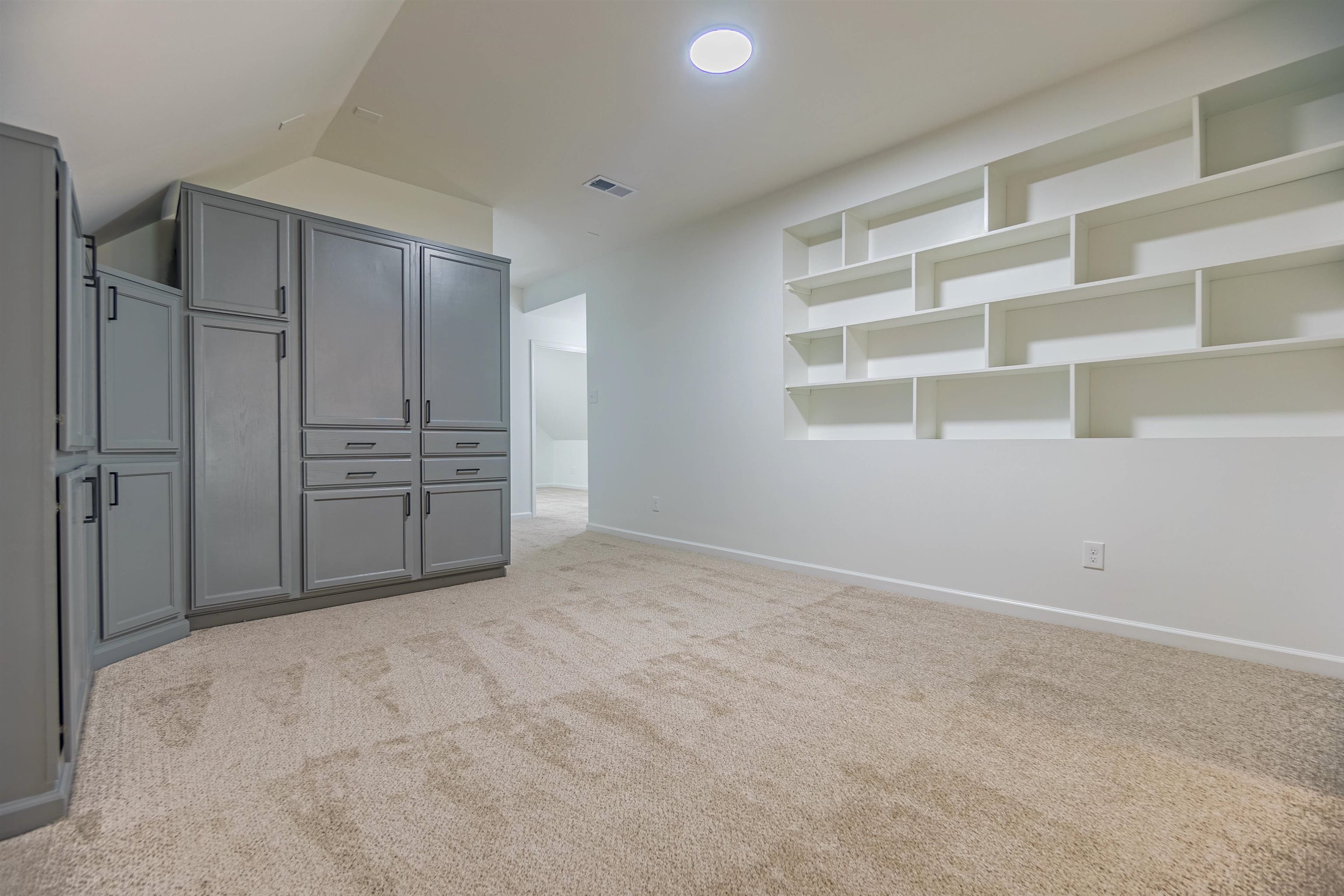 Interior space featuring light carpet and vaulted ceiling