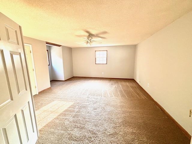 Carpeted spare room with a textured ceiling and ceiling fan