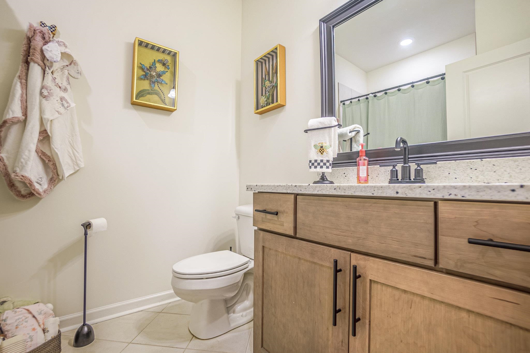 Bathroom featuring toilet, vanity, and tile patterned flooring