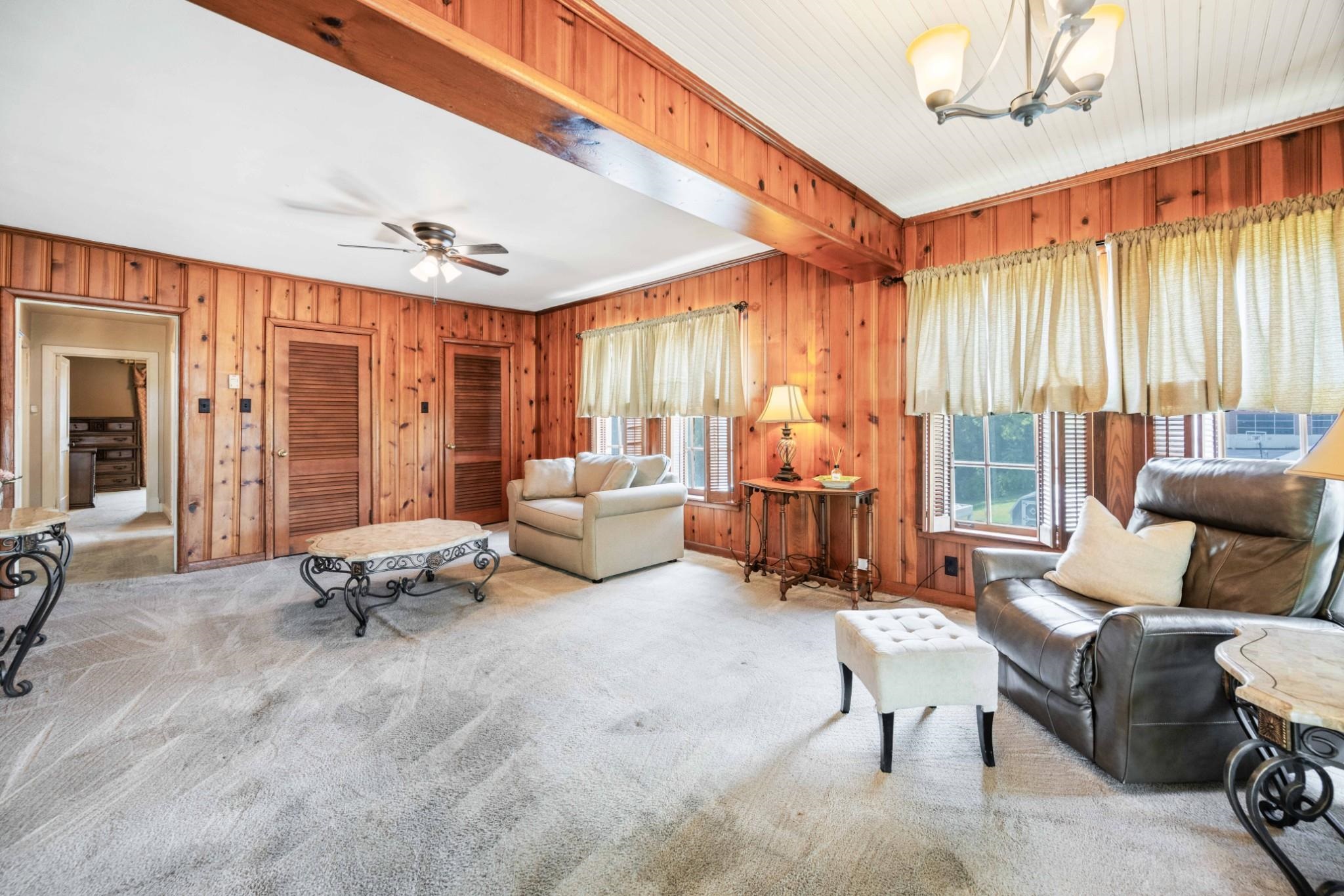 Large & casual den features the knotty pine walls & shuttered windows.