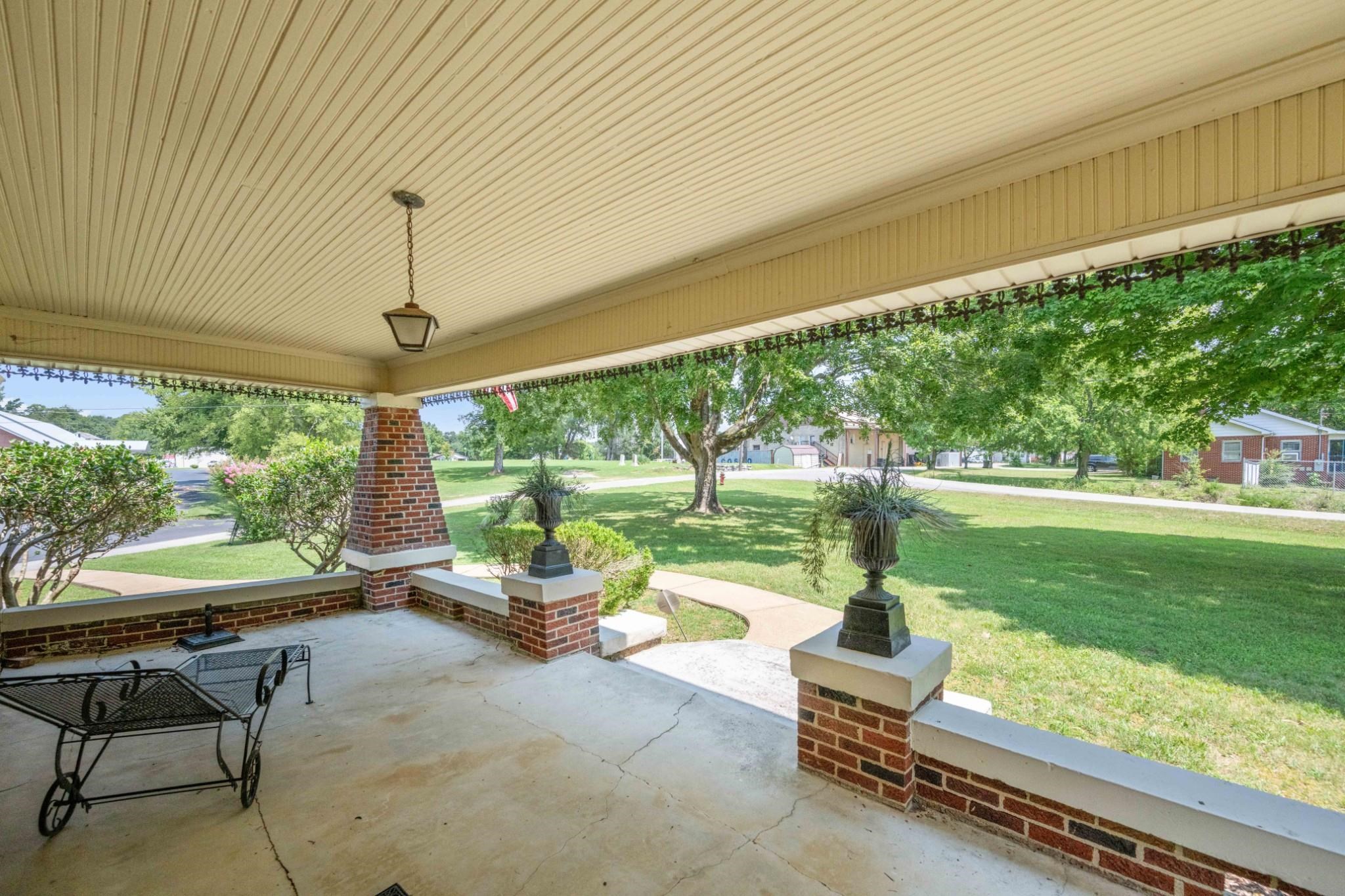 Covered, concrete front porch still has its original tongue & groove wood ceiling!