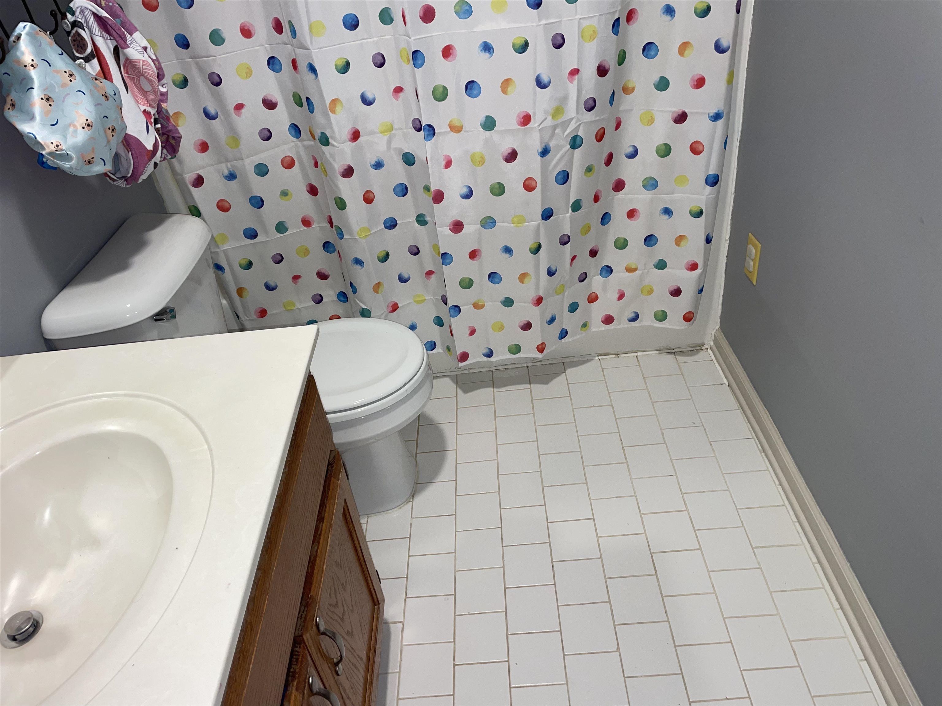 Bathroom with toilet, tile patterned floors, and vanity