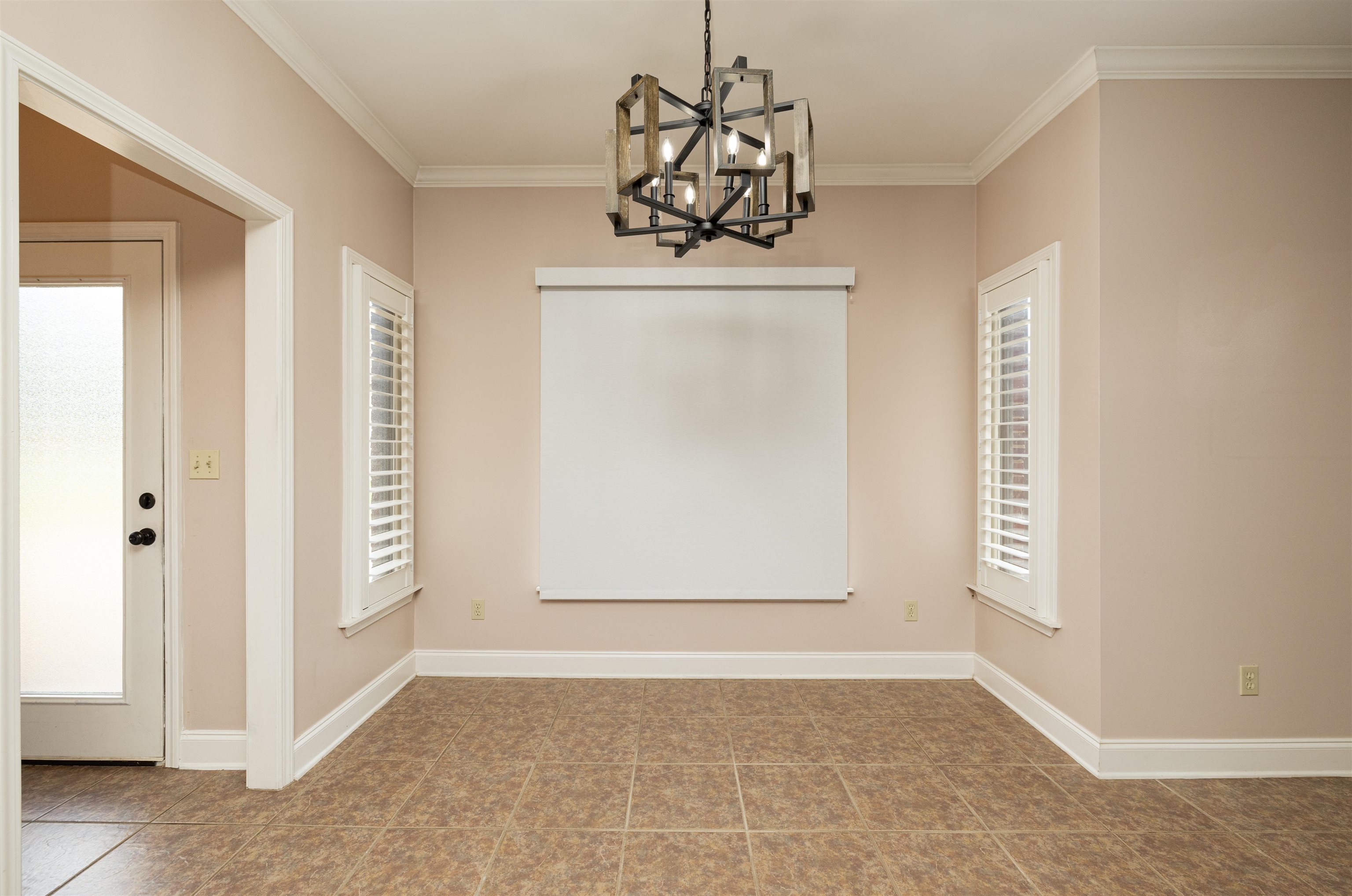 Unfurnished dining area featuring crown molding, tile patterned floors, plenty of natural light, and a chandelier