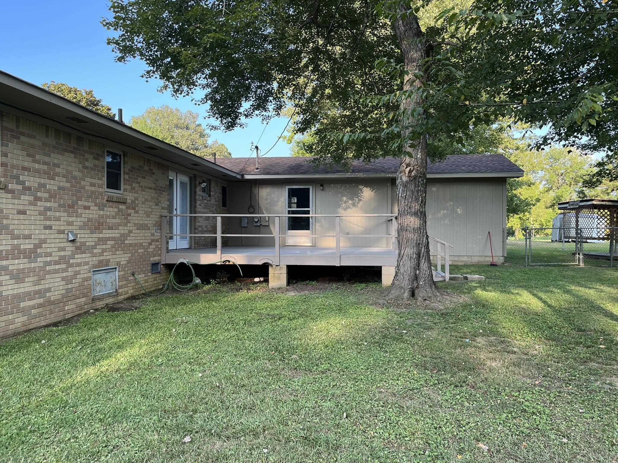 Rear view of property with a yard