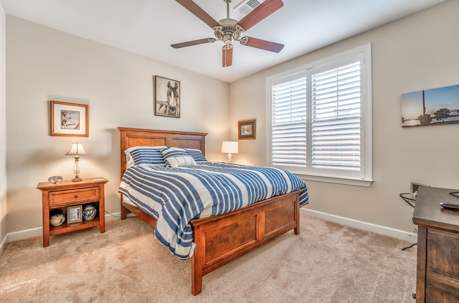 Bedroom with light colored carpet and ceiling fan