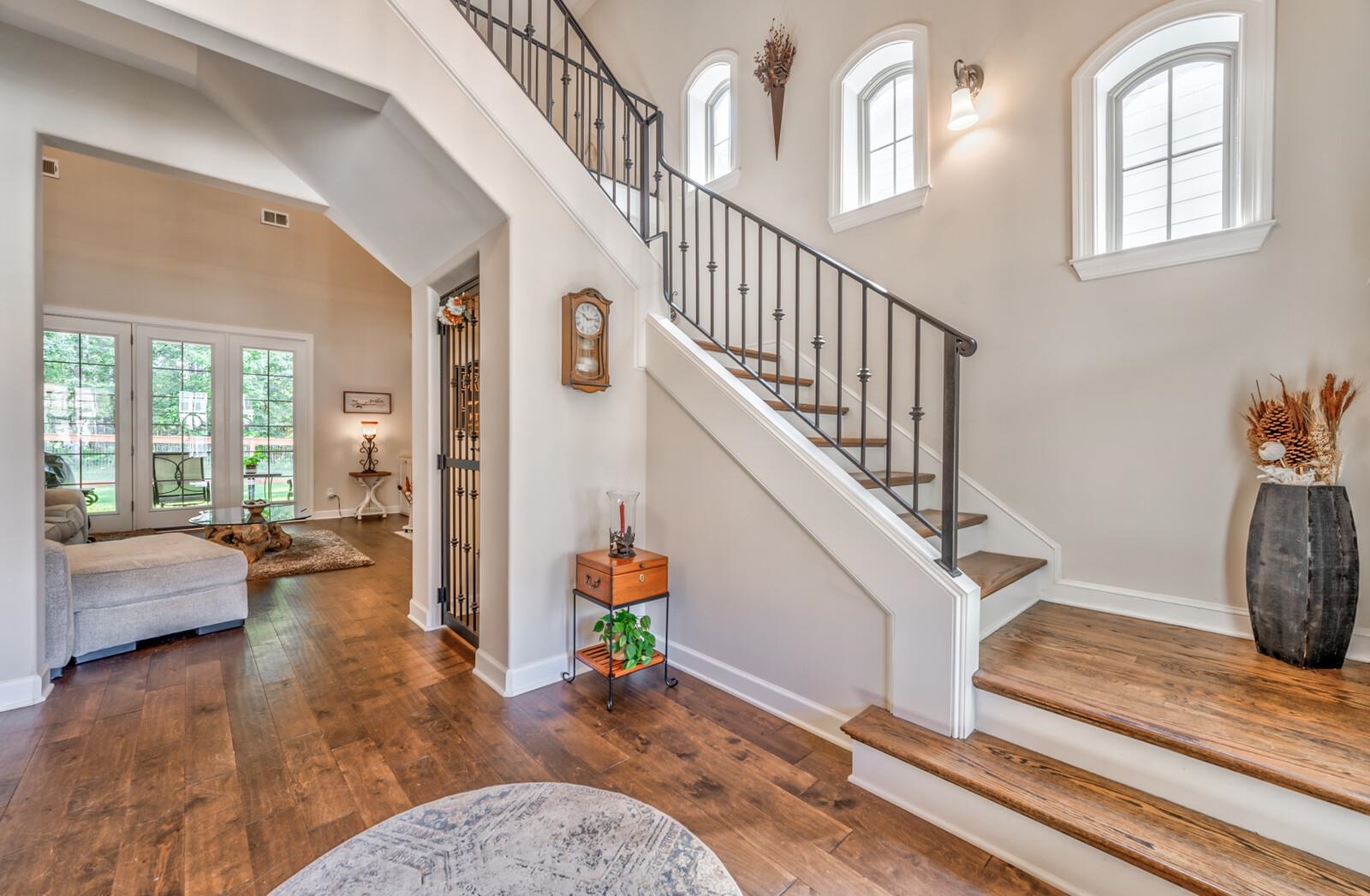 Staircase with a high ceiling and dark wood-type flooring