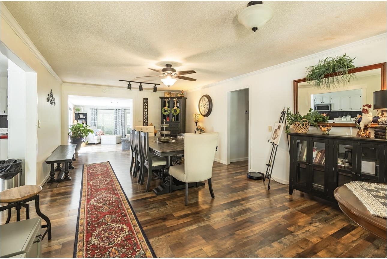 Dining area featuring a textured ceiling, ornamental molding, dark hardwood / wood-style floors, and ceiling fan