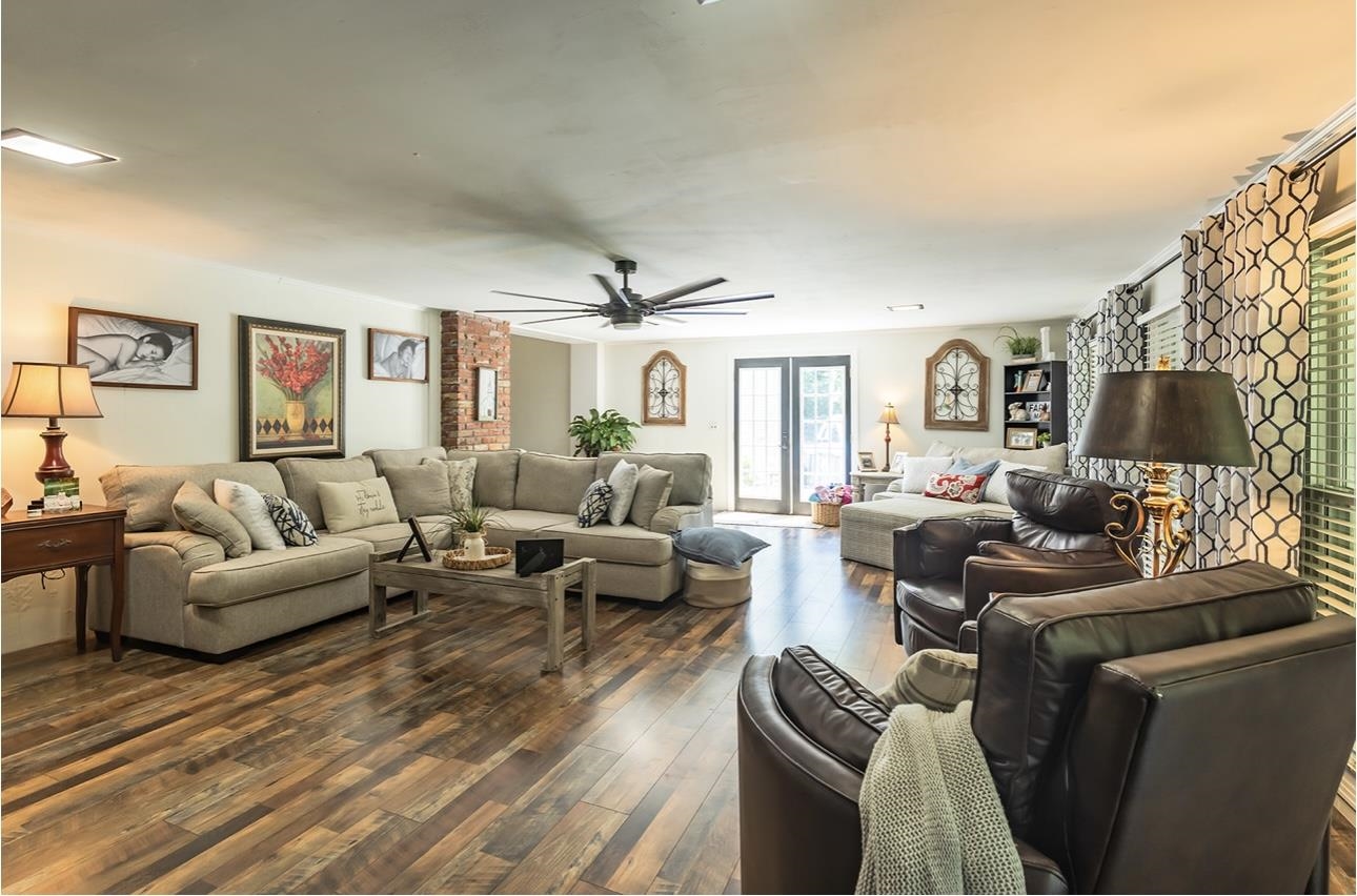 Living room featuring ceiling fan and dark hardwood / wood-style flooring