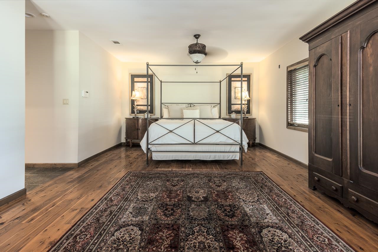 Bedroom featuring dark wood-type flooring and ceiling fan