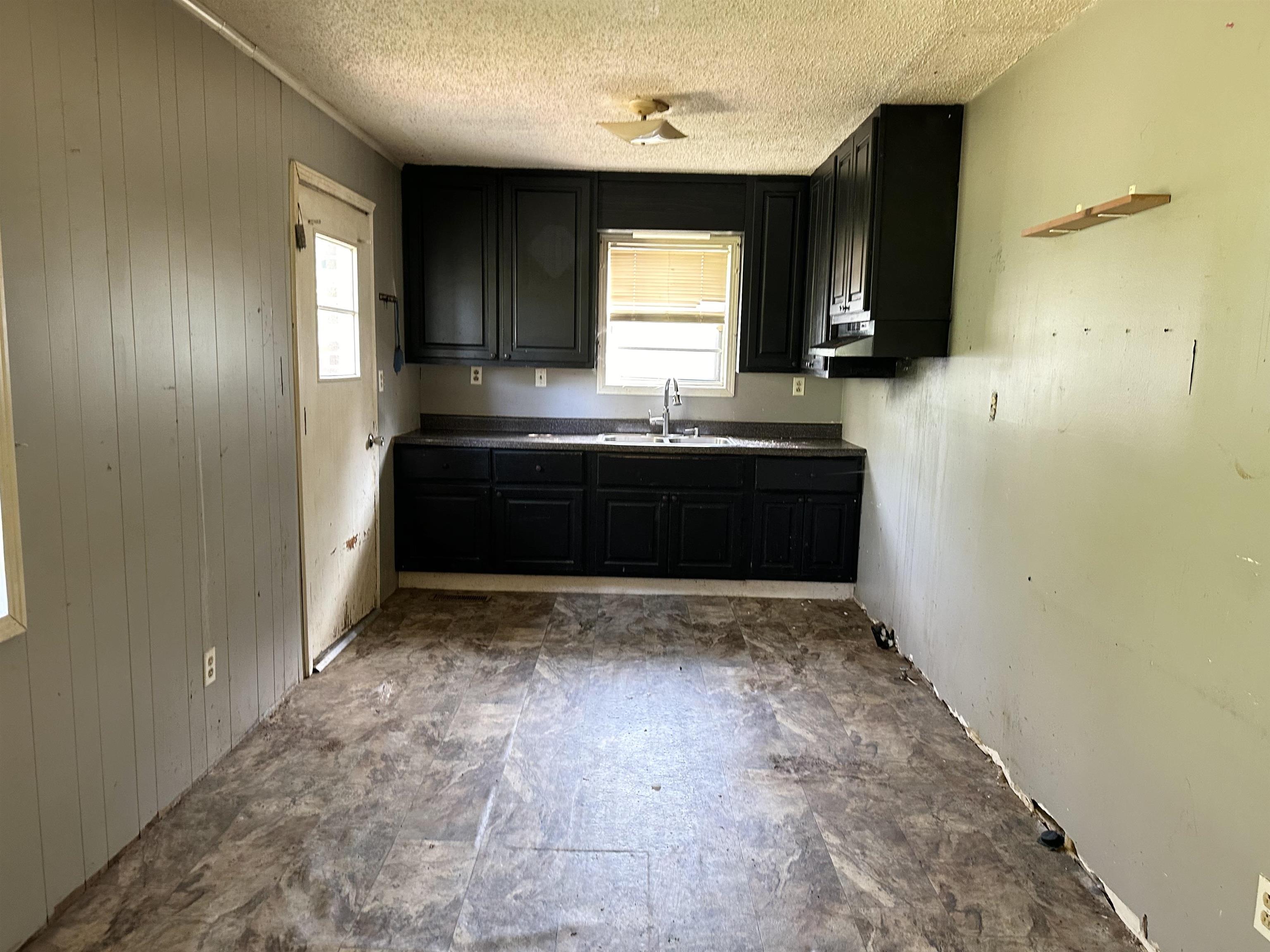 Kitchen with sink, a textured ceiling, and tile patterned floors