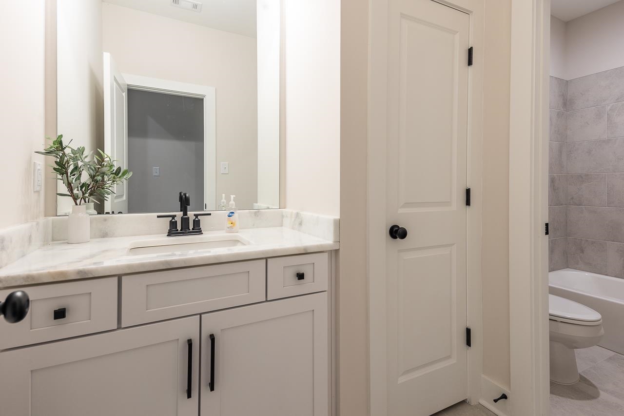 Full bathroom featuring toilet, shower / bathing tub combination, vanity, and tile patterned flooring