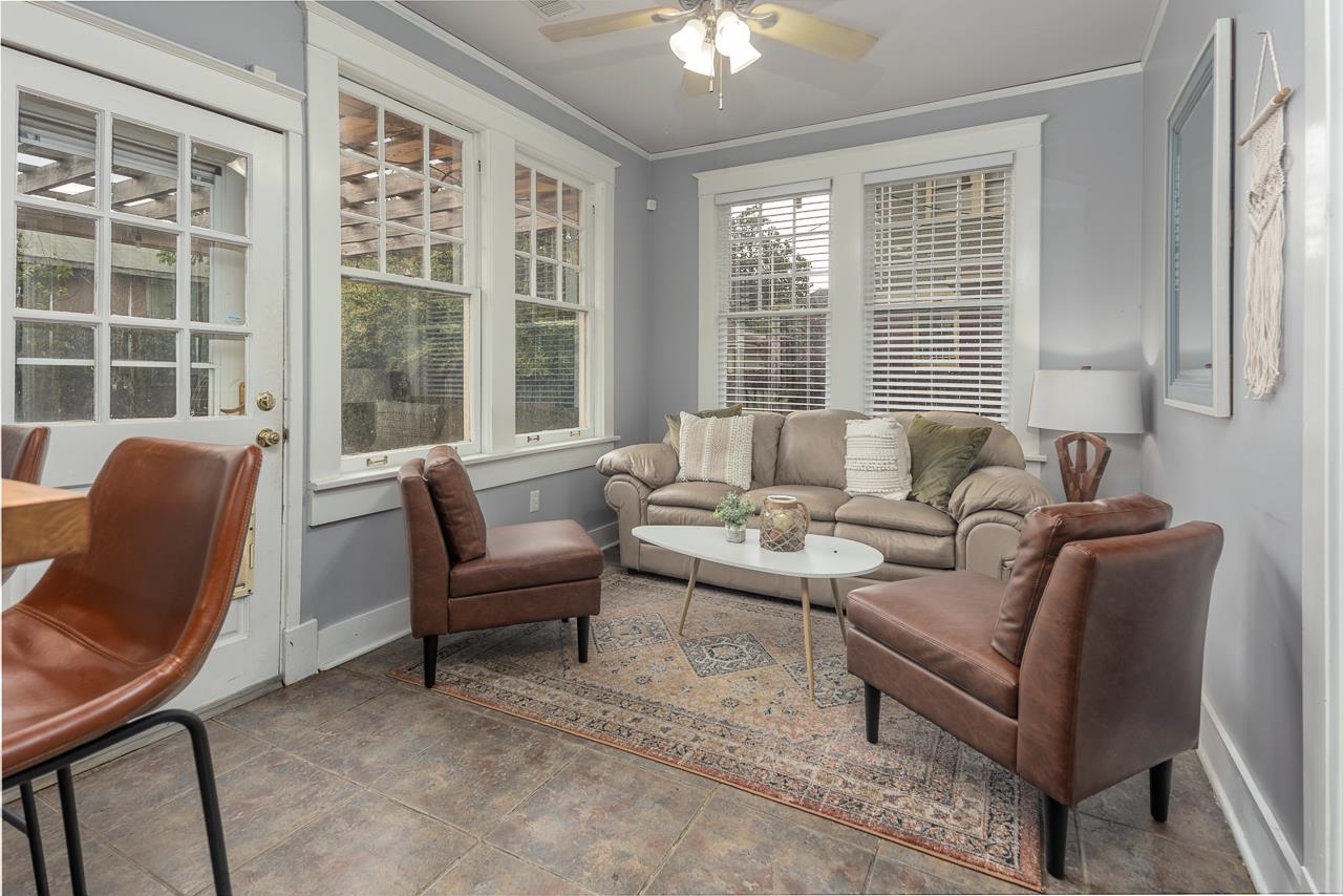 Living area with ceiling fan, ornamental molding, and tile patterned flooring