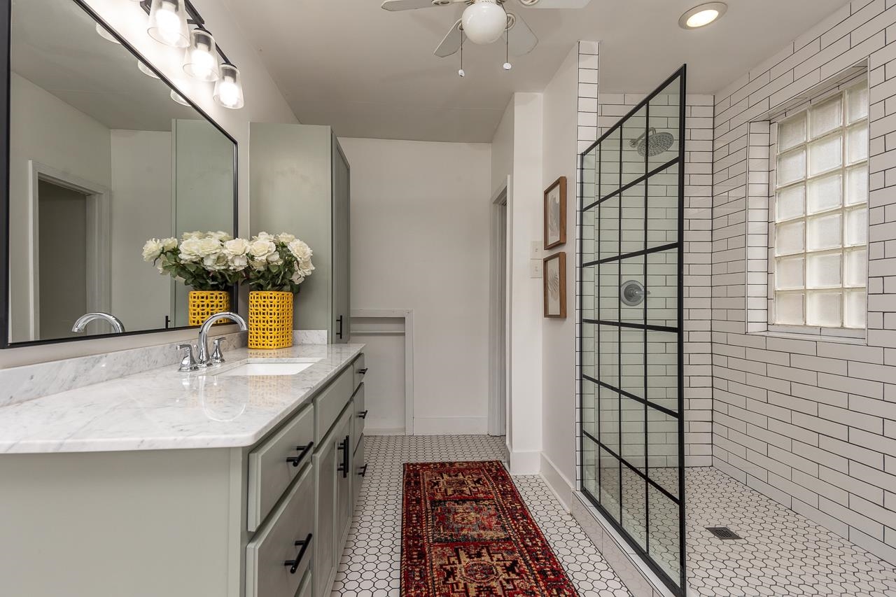 Bathroom with ceiling fan, vanity, tile patterned flooring, and a shower with shower door