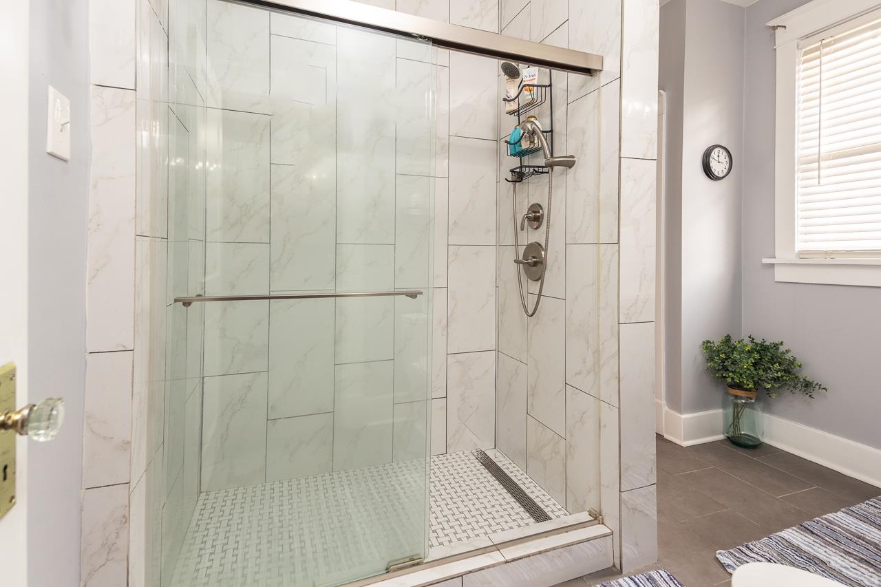 Bathroom with tile patterned floors and a shower with door