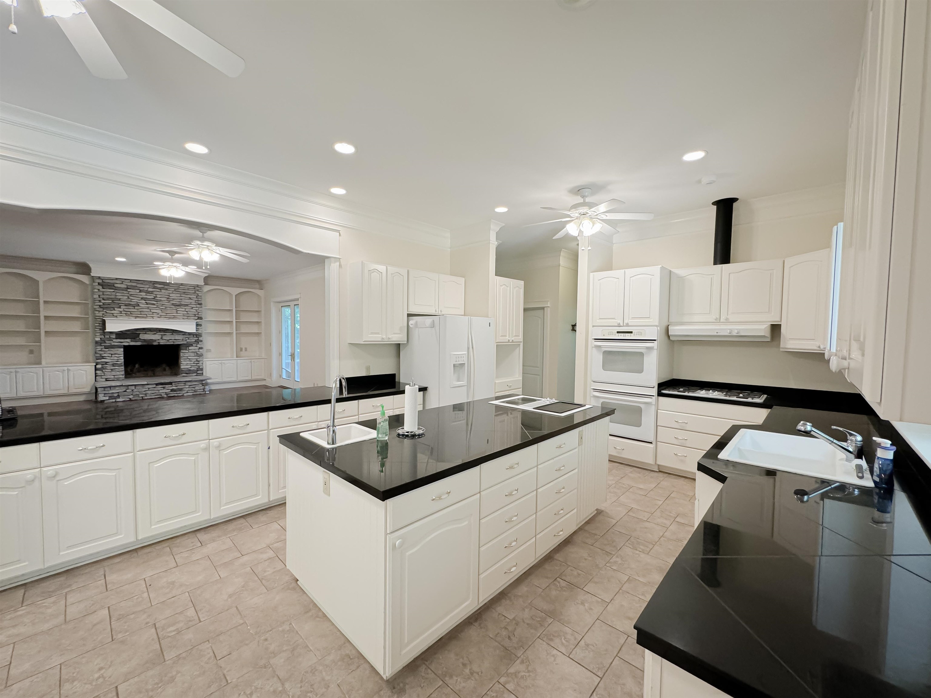 Kitchen with ceiling fan, white cabinetry, and white appliances