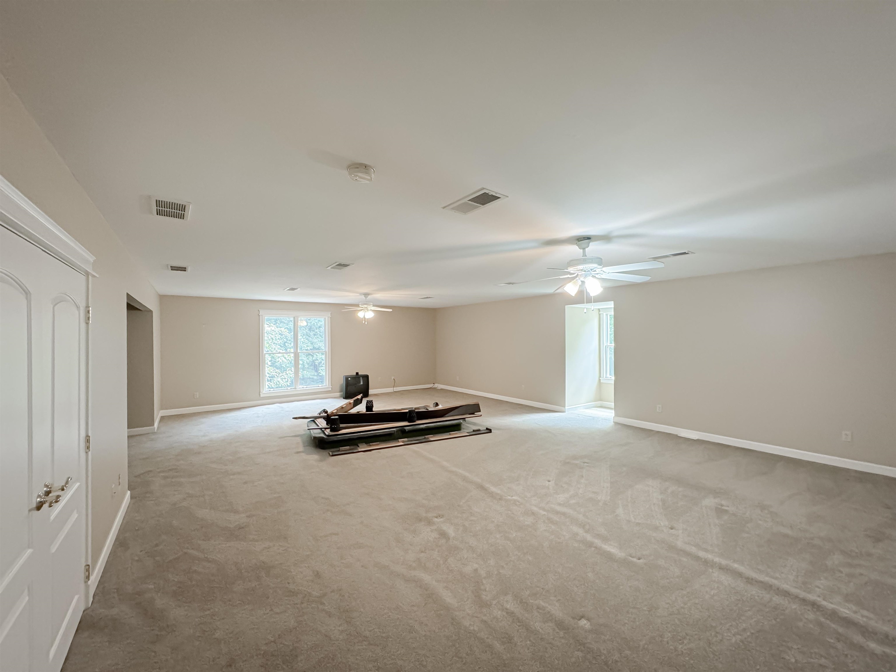 Carpeted empty room featuring ceiling fan